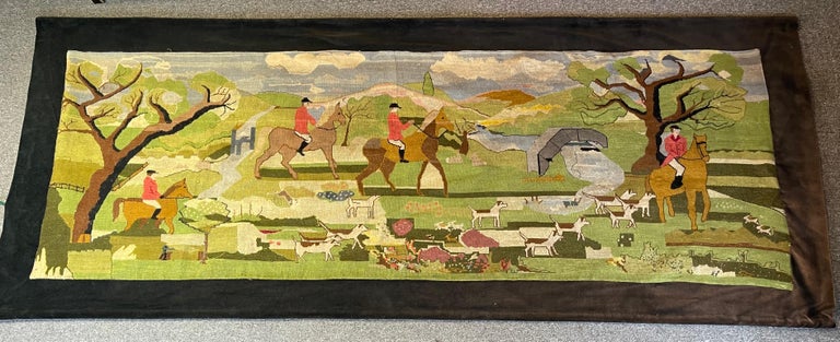 An exceptionally large mid 20th C. hand made needlepoint hunt-themed tapestry wall hanging bordered in brown velvet. The measurements without the border are 103.25