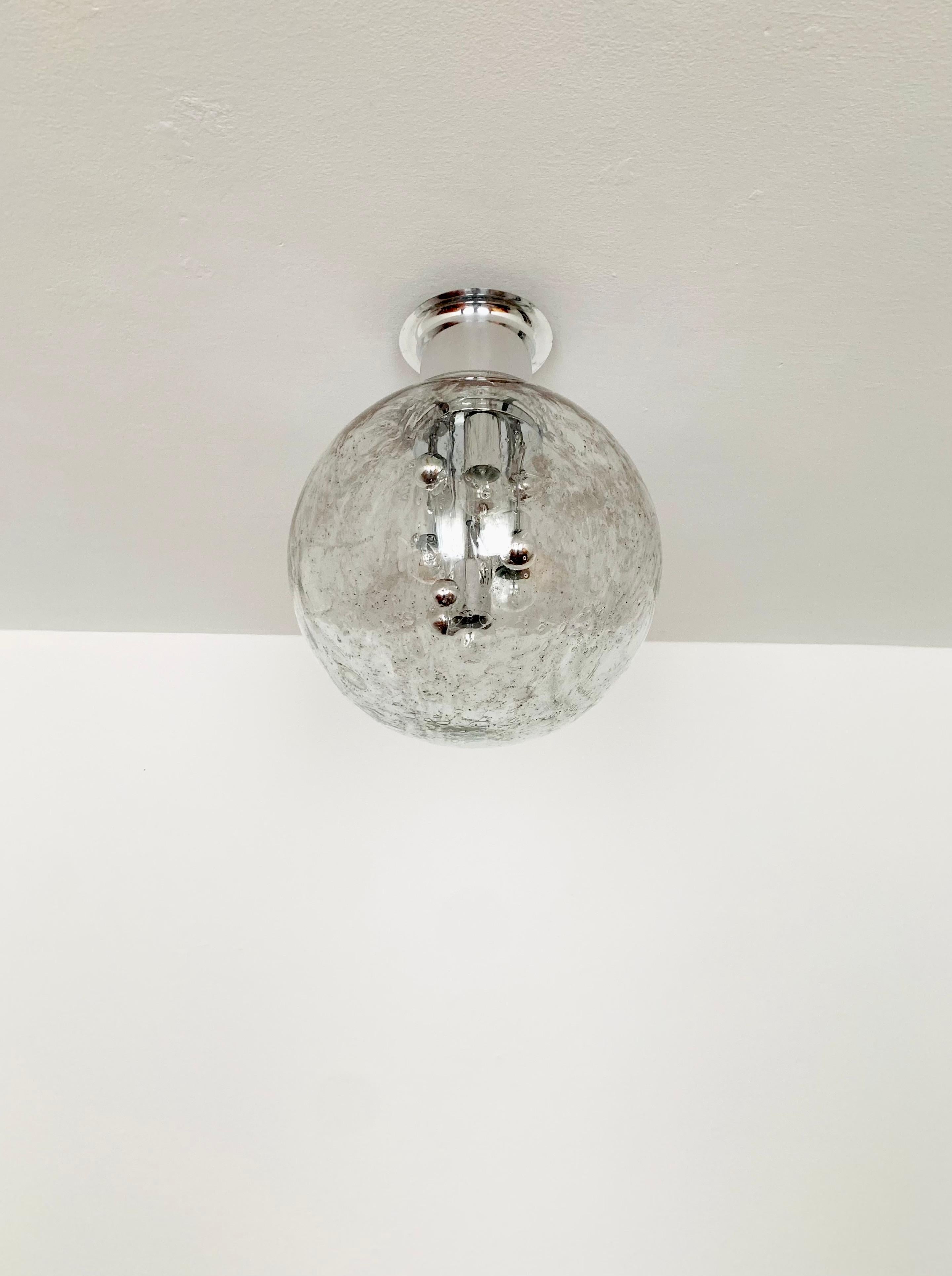 Very beautiful and large ice glass Big Ball ceiling lamp by Doria from the 1960s.
Very elegant Hollywood Regency design with a fantastically glamorous look.
The structure in the glass creates a very sparkling light.

Manufacturer: