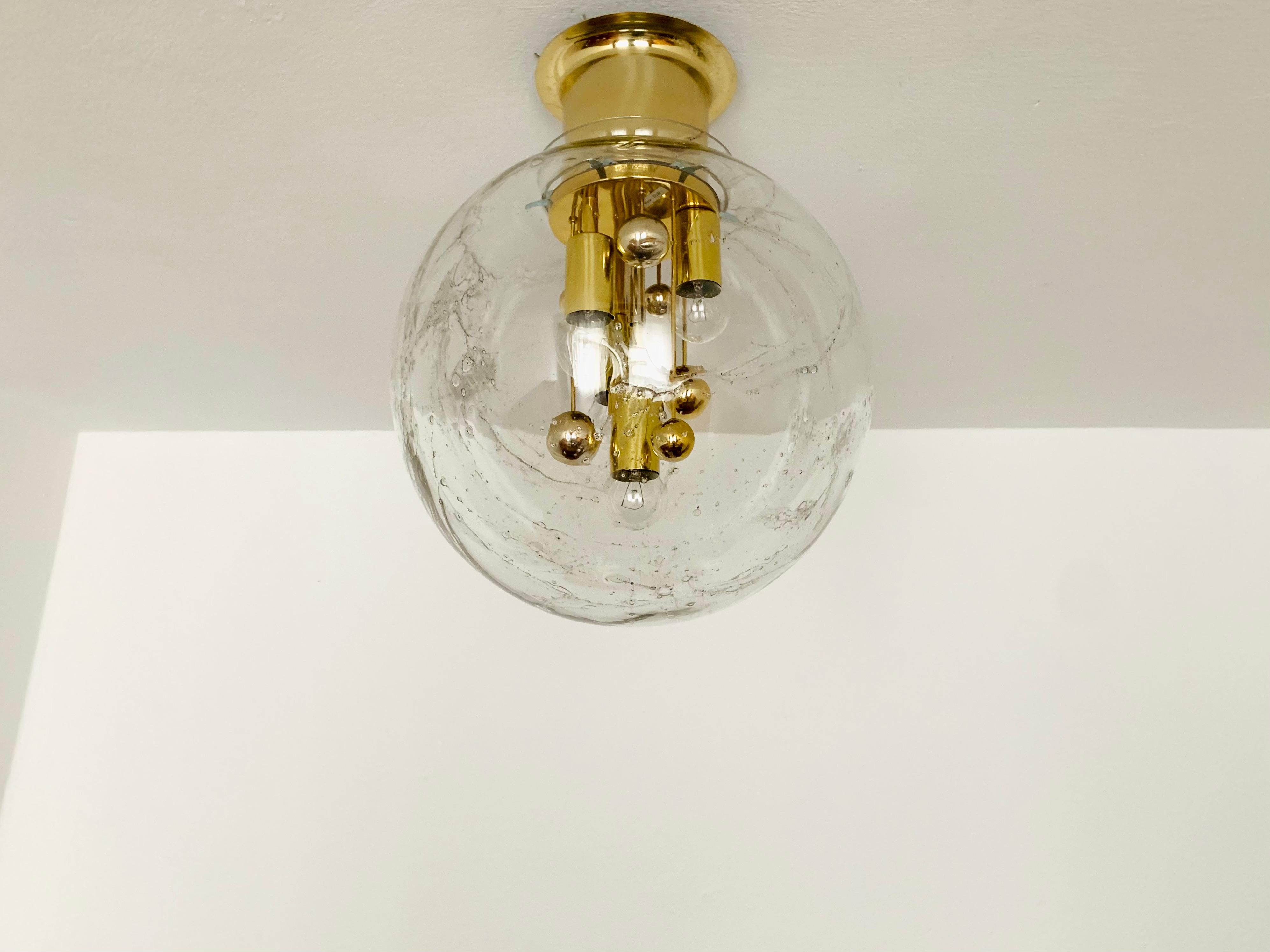 Very beautiful and large ice glass Big Ball ceiling lamp by Doria from the 1960s.
Very elegant Hollywood Regency design with a fantastically glamorous look.
The structure in the glass creates a very sparkling light.

Manufacturer: