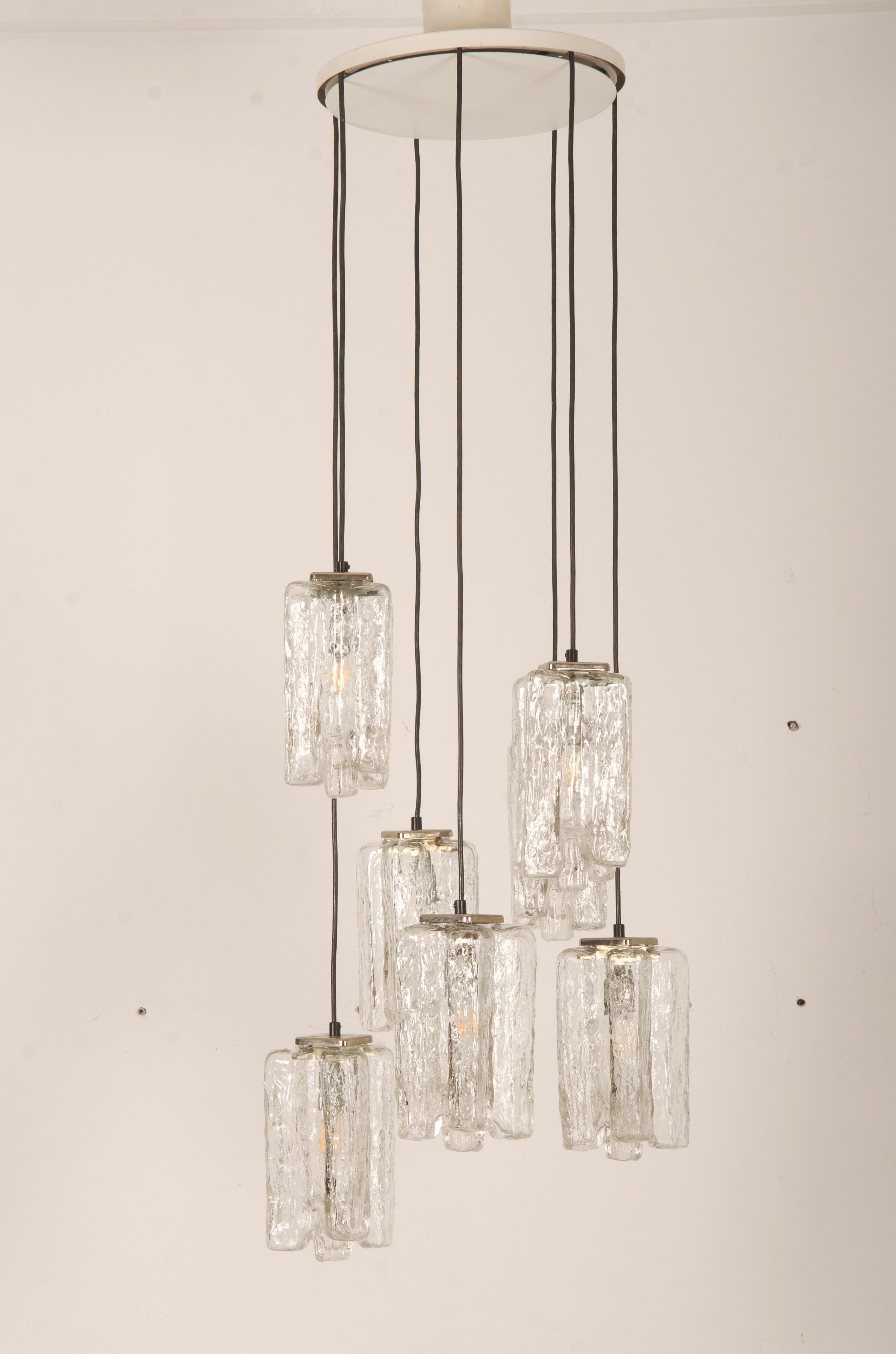 Bellissimo lampadario realizzato con supporti in ottone nichelato e sette paralumi in vetro soffiato a mano, ciascuno dotato di prese E14. Realizzato da. J.T. Kalmar negli anni '70.