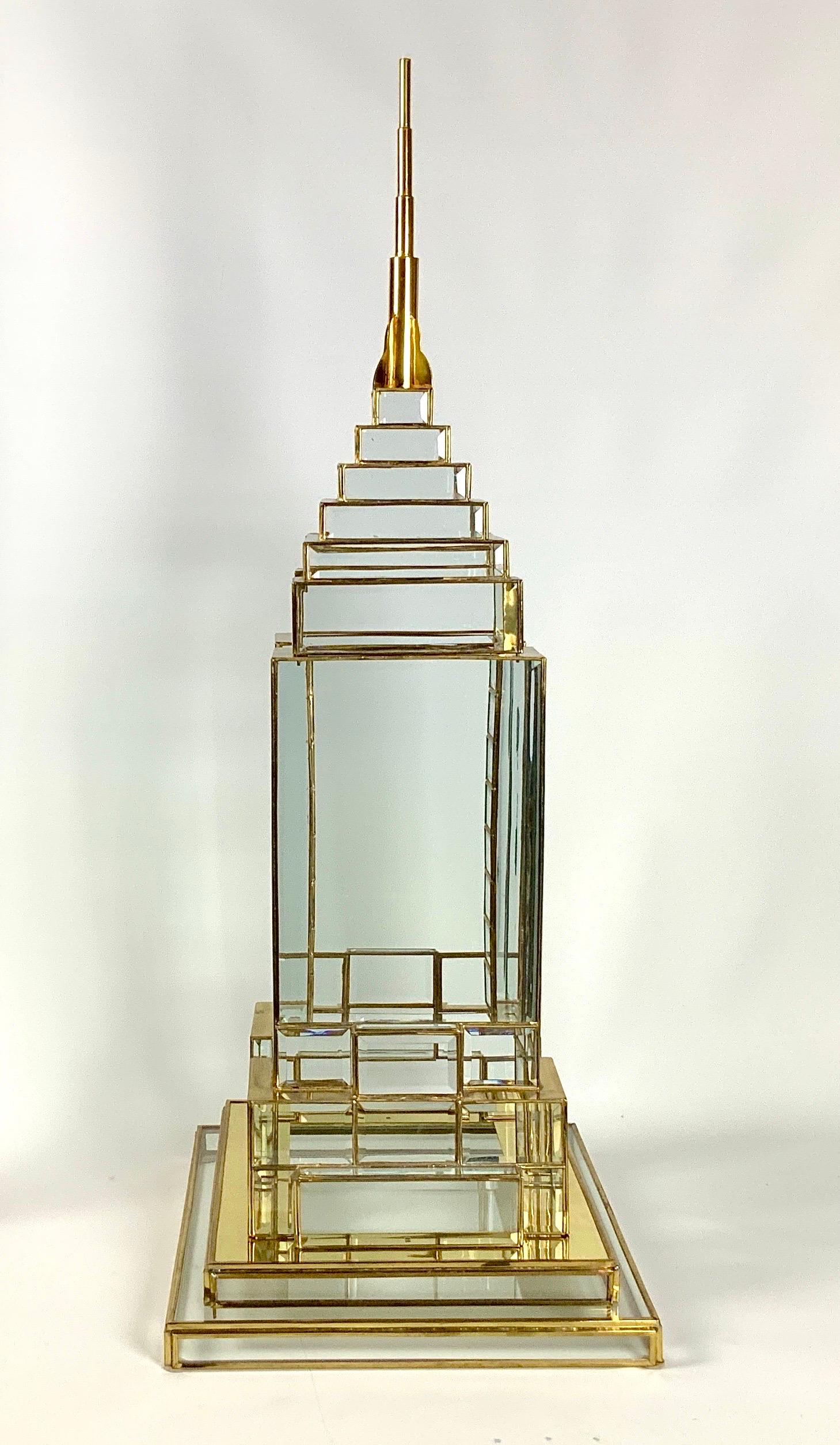 Una grande scultura iconica dell'Empire State Building di New York. Questo imponente pezzo è realizzato a mano in vetro smussato e incorniciato in ottone. Un pezzo di sicuro effetto, da solo o collocato su un piedistallo come centrotavola.
