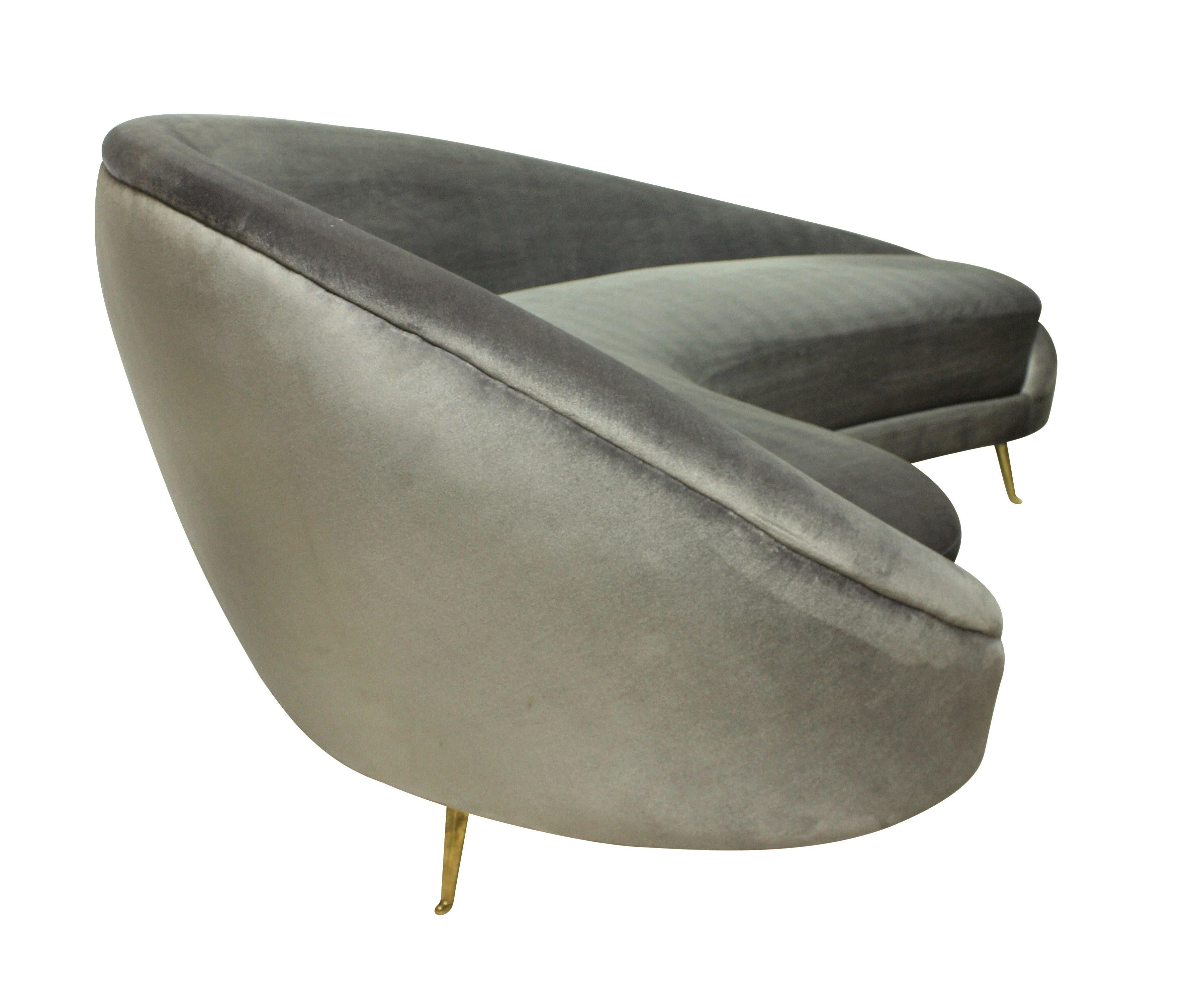 A large Italian curved asymmetrical sofa in the style Ico Parisi, on brass feet by ISA, and newly upholstered in grey silk velvet.