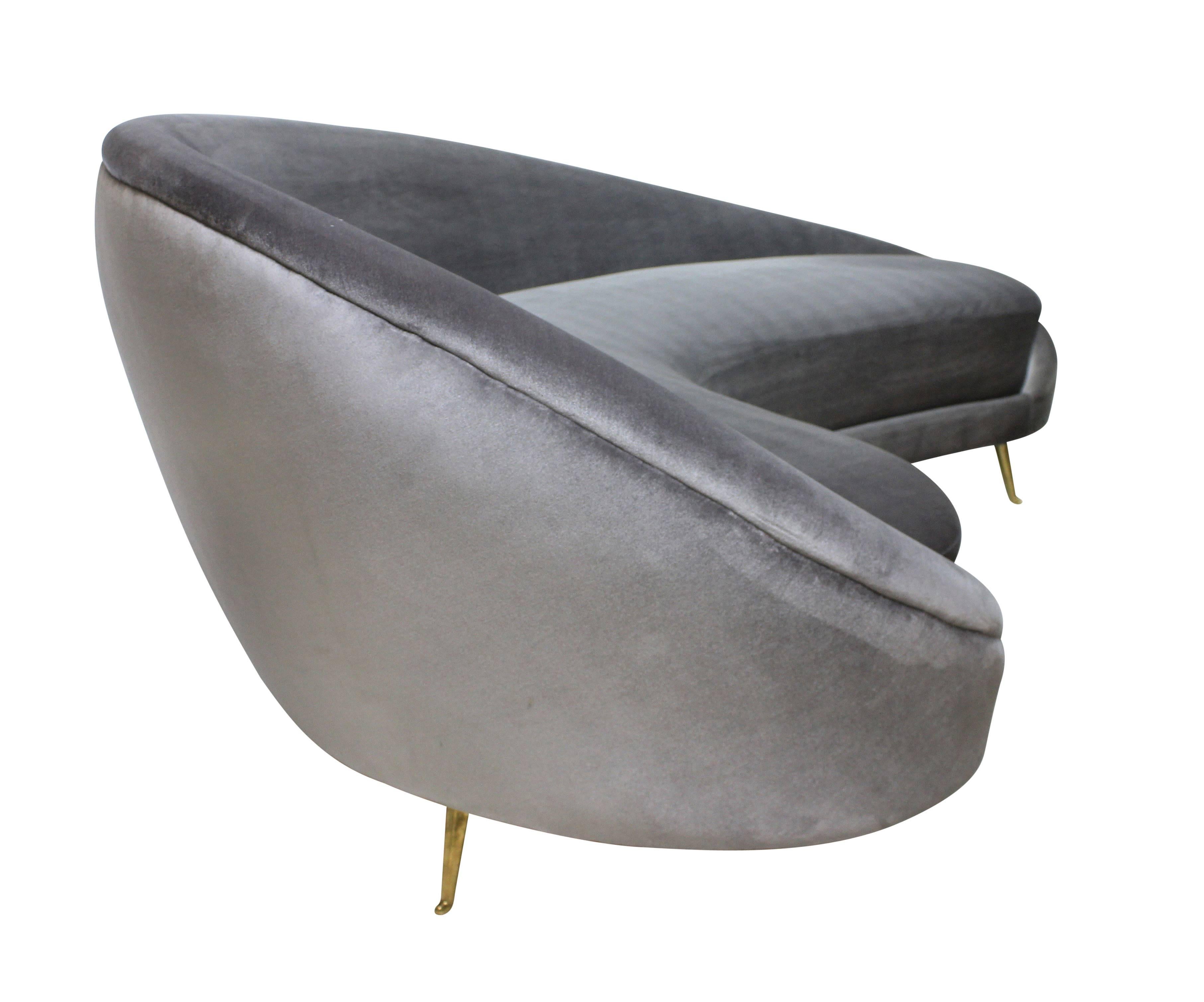 A large Italian curved asymmetrical sofa in the style of Ico Parisi, on brass feet by I.S.A and newly upholstered in a silver-grey silk velvet.