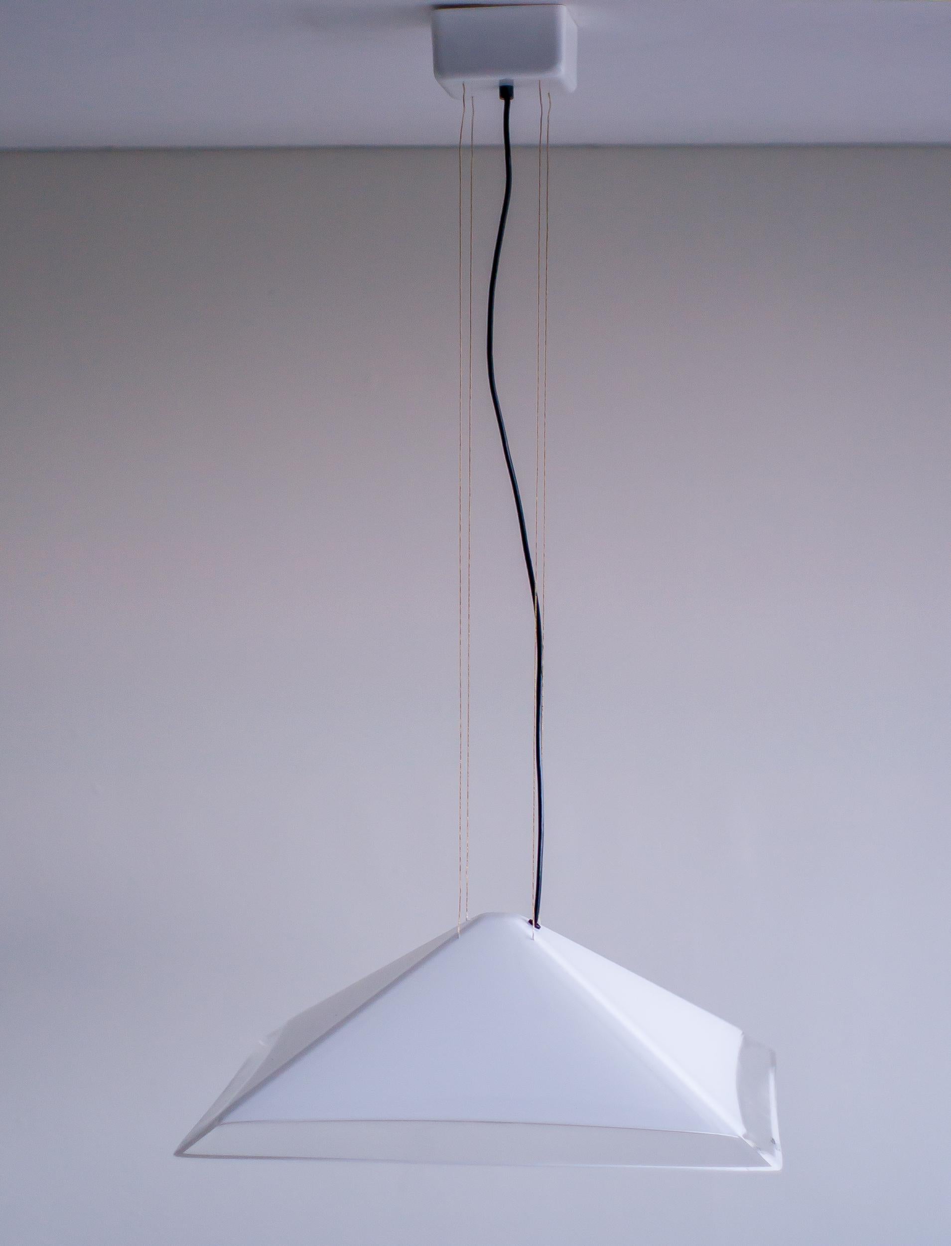 Elevate your space with this striking iGuzzini pendant light, a statement piece that blends modern design with functional elegance. Crafted from white plexiglass with subtly translucent edges, the pyramid-shaped shade emits a soft, ambient glow