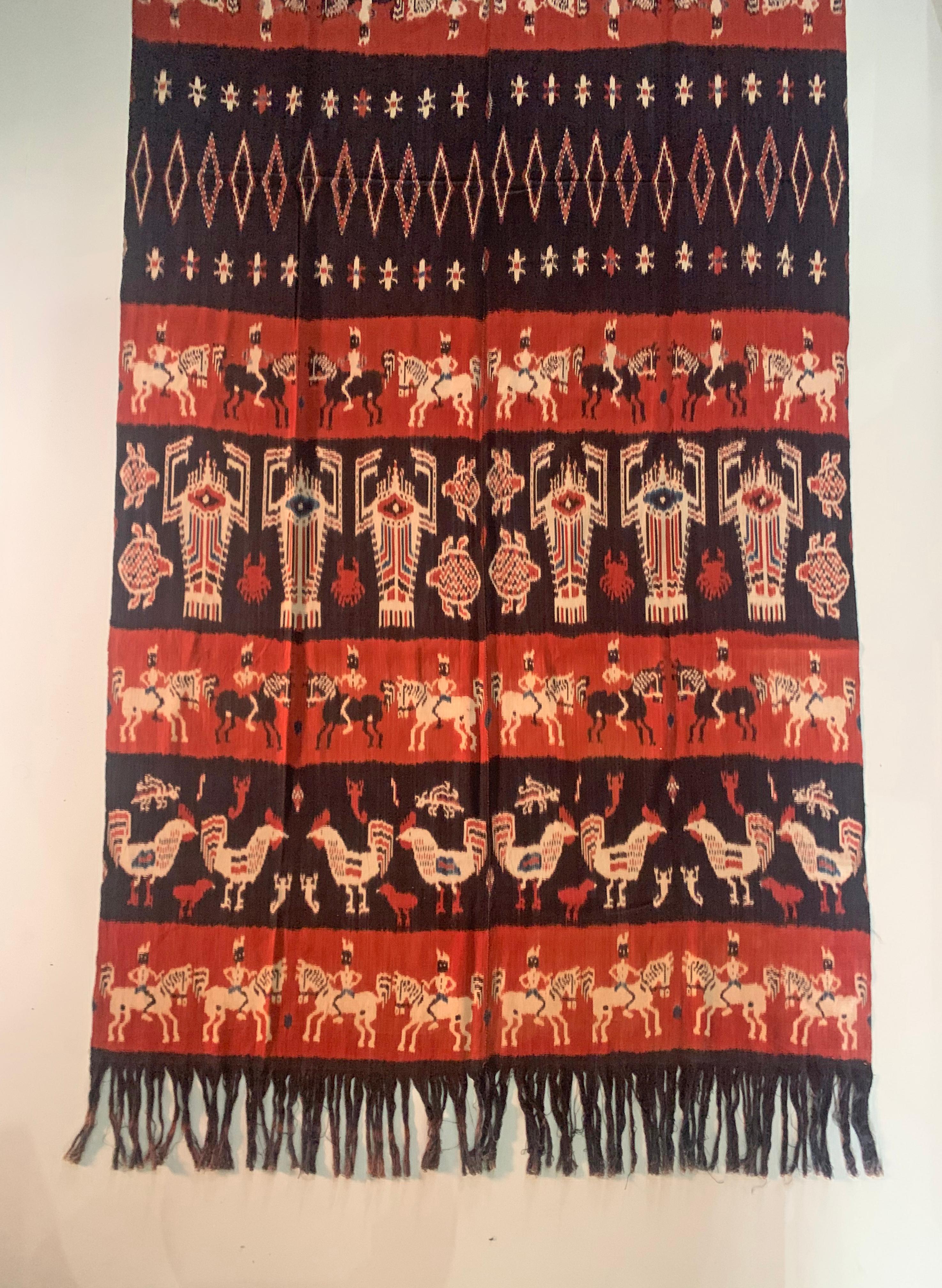 This Ikat textile originates from the Island of Sumba, Indonesia. It is hand-woven using naturally dyed yarns via a method passed on through generations. It features a stunning array of distinct tribal patterns as well as men on horse, chicken, ,