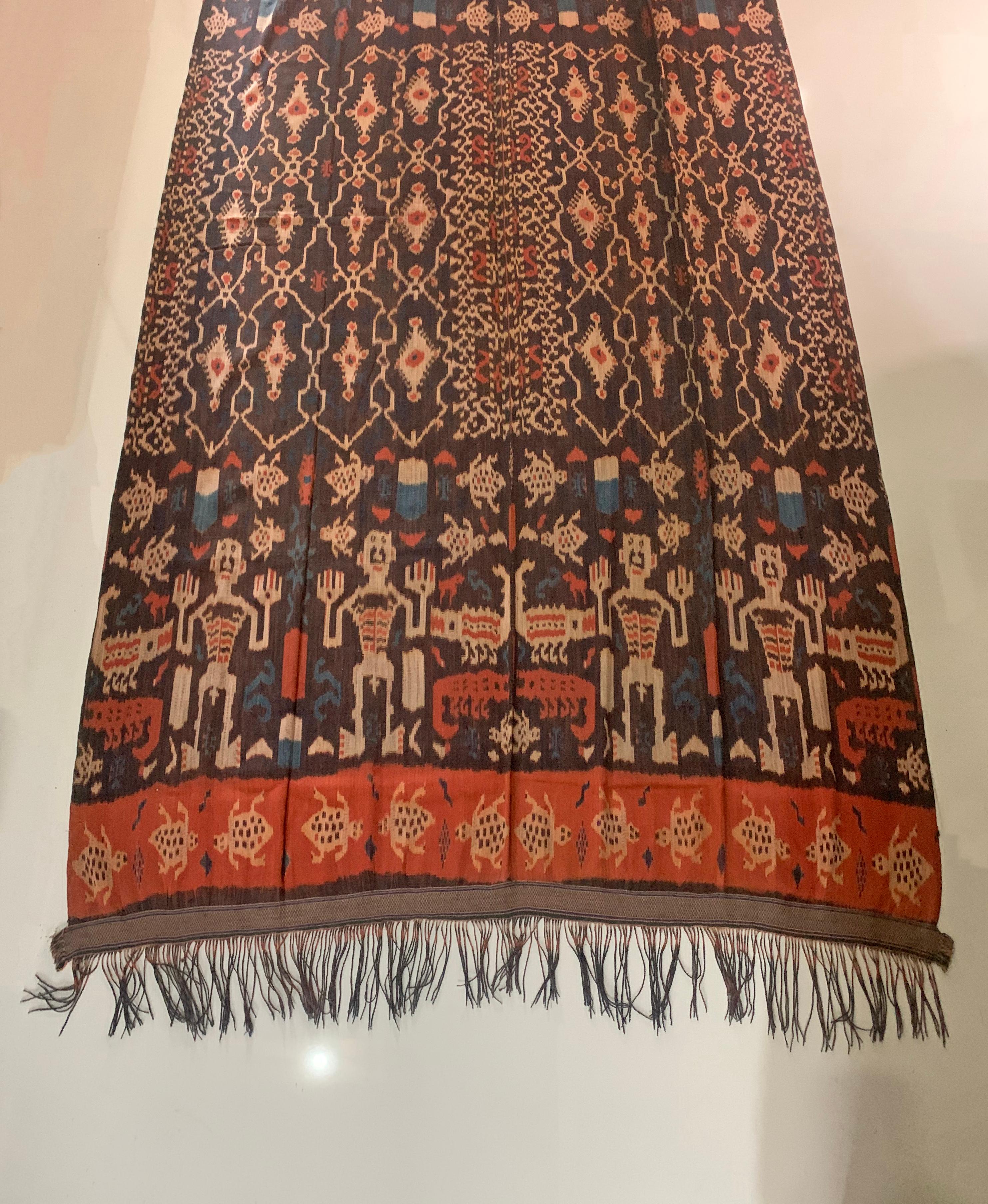 This Ikat textile originates from the Island of Sumba, Indonesia. It is hand-woven using naturally dyed yarns via a method passed on through generations. It features a stunning array of distinct tribal patterns as well as tribes men, crocodile &