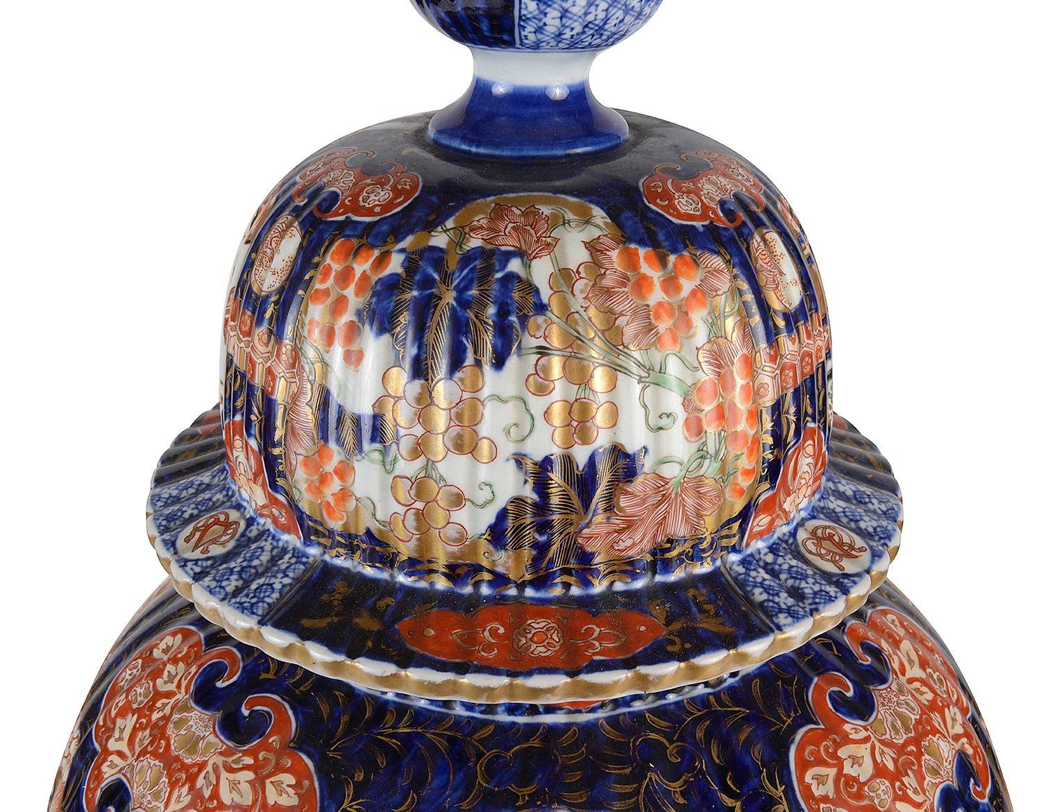 A very impressive and decorative 19th Century Japanese Imari lidded vase. Having raised rib decoration to the lid and vase, wonderful bold blue and orange colouring, classical motif and scrolling gilded highlights. Inset hand painted panels