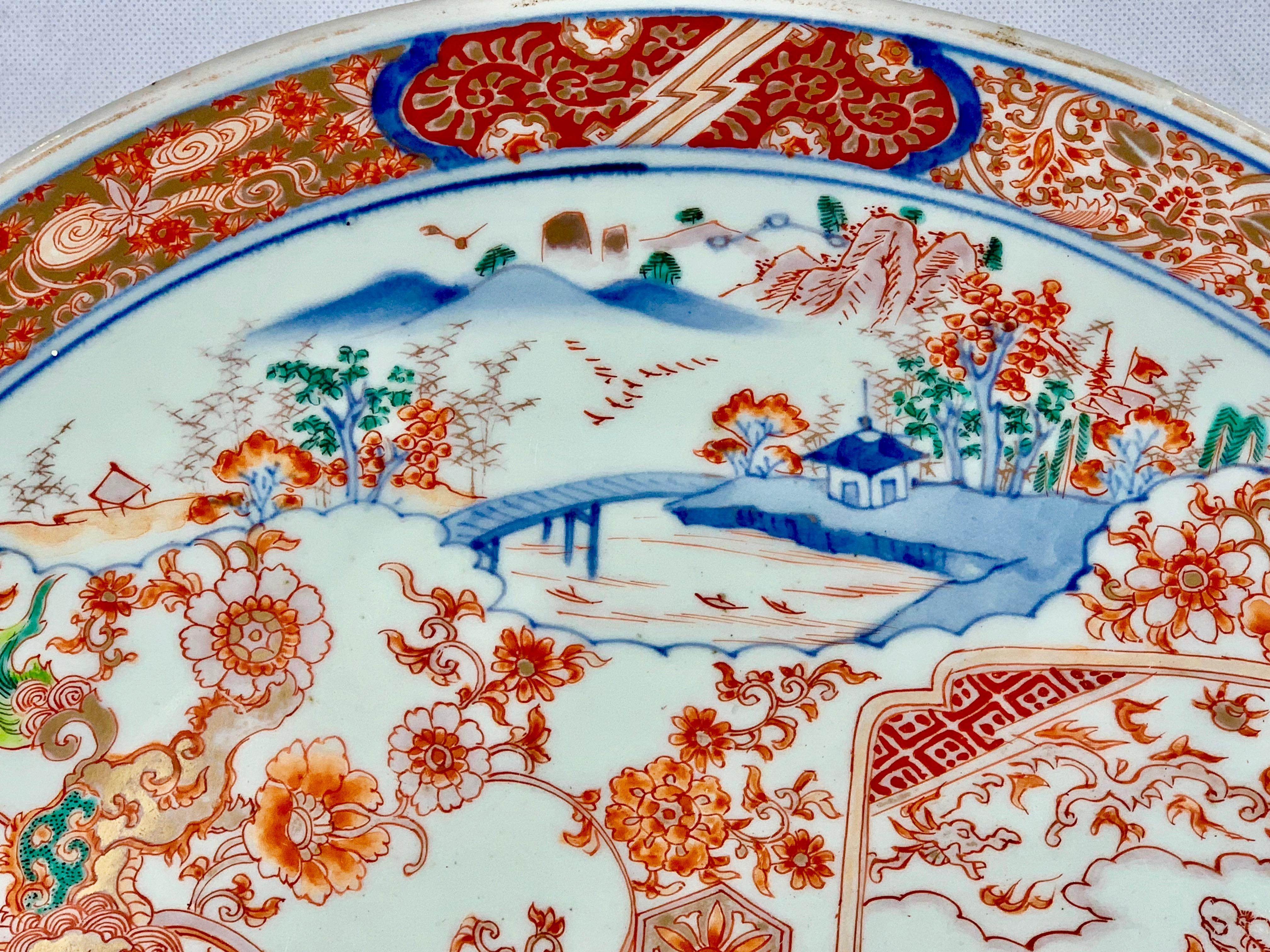 Large finely decorated Japanese Meiji period  Imari porcelain charger. The decoration consists of shaped panels overlayed on floral sprays. The stylized border has cloud forms on a fret work background. The enamel colors have a cobalt blue