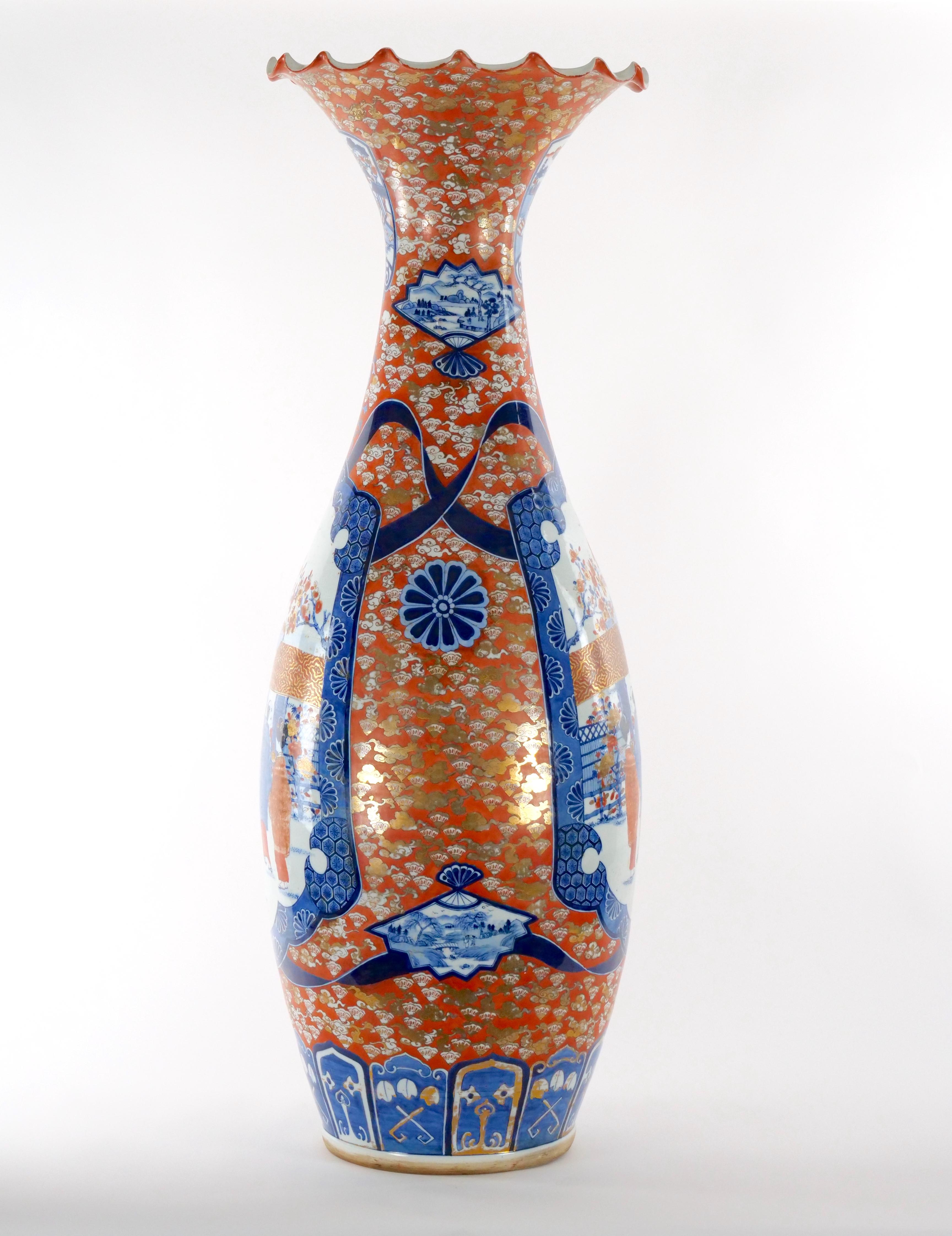 Monumentale, trompetenförmige, dekorative Bodenvase aus dekoriertem Imari-Porzellan. Die Bodenvase mit Baluster  zum Hals hin zu einem gekräuselten Rand ausläuft. Jede Seite des  Der Körper ist in Blau und Rot mit weißen Akzenten gehalten und zeigt