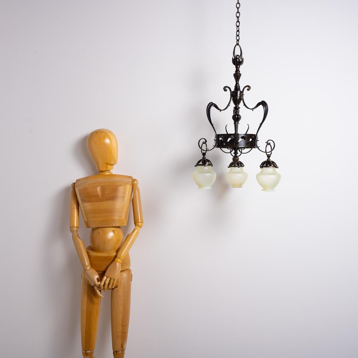 LARGE HIGH QUALITY BRITISH ARTS & CRAFTS THREE ARM PENDANT LIGHT

Command attention with this large and impressive three-arm chandelier, an exquisite example of British Arts & Crafts craftsmanship from the early 1900s. The unsigned piece speaks