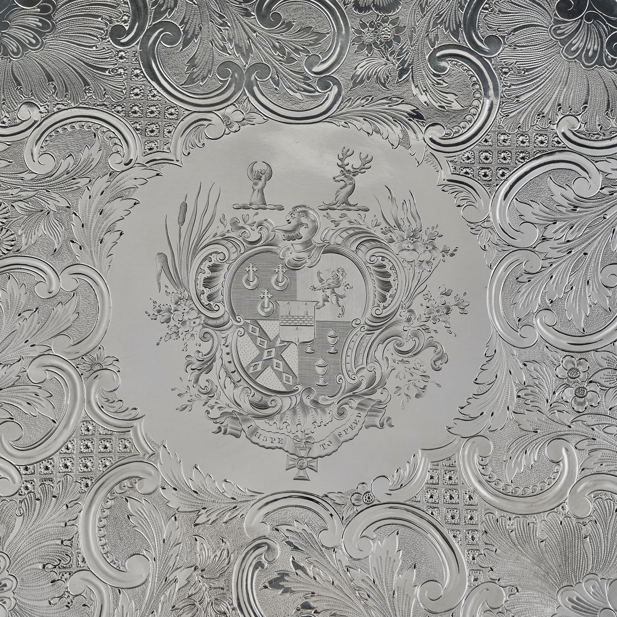 A superb quality antique silver salver  or charger in the highly decorative rococo style. Made during the reign of George IV, this large silver salver has a cast openwork border finely detailed with both chinoiserie decorations and bacchanalian