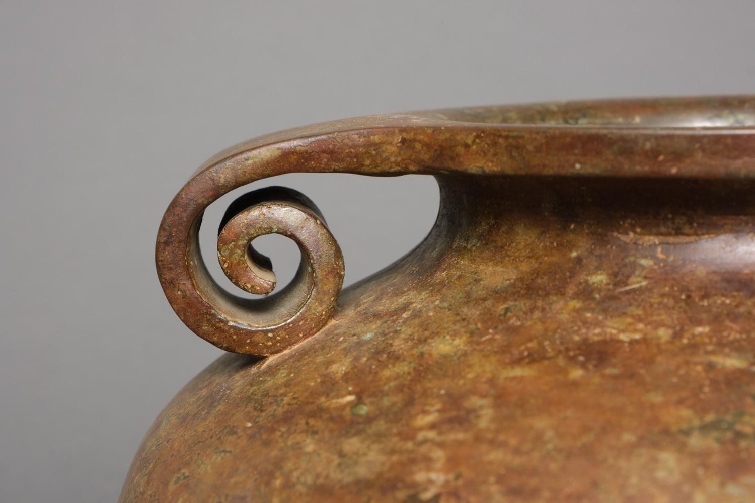 Large and impressive brown patinated bronze urn-shaped vase. The rim is flattened and turns at the sides into a pair of spiralling handles (noshimimi). It has a lovely clouded brown/ochre patina all over its large protruding body.

The vase is