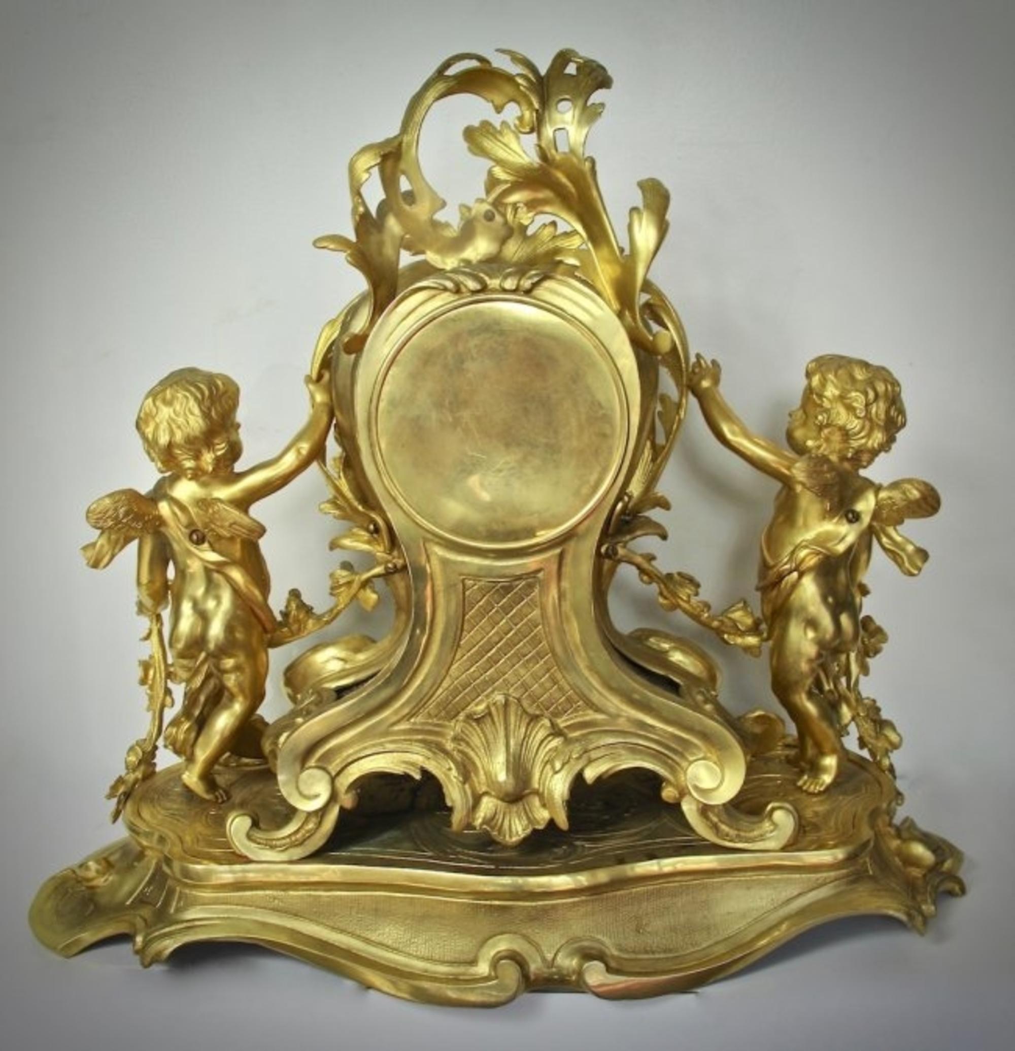 Beautiful large and impressive Louis XV gilt bronze mantel (fireplace) clock
French, circa 1890.
The asymmetrical shaped clock with an enamel dial, flanked by two putti, standing atop a platform with open work cast scrolls.
Measures: Height 21