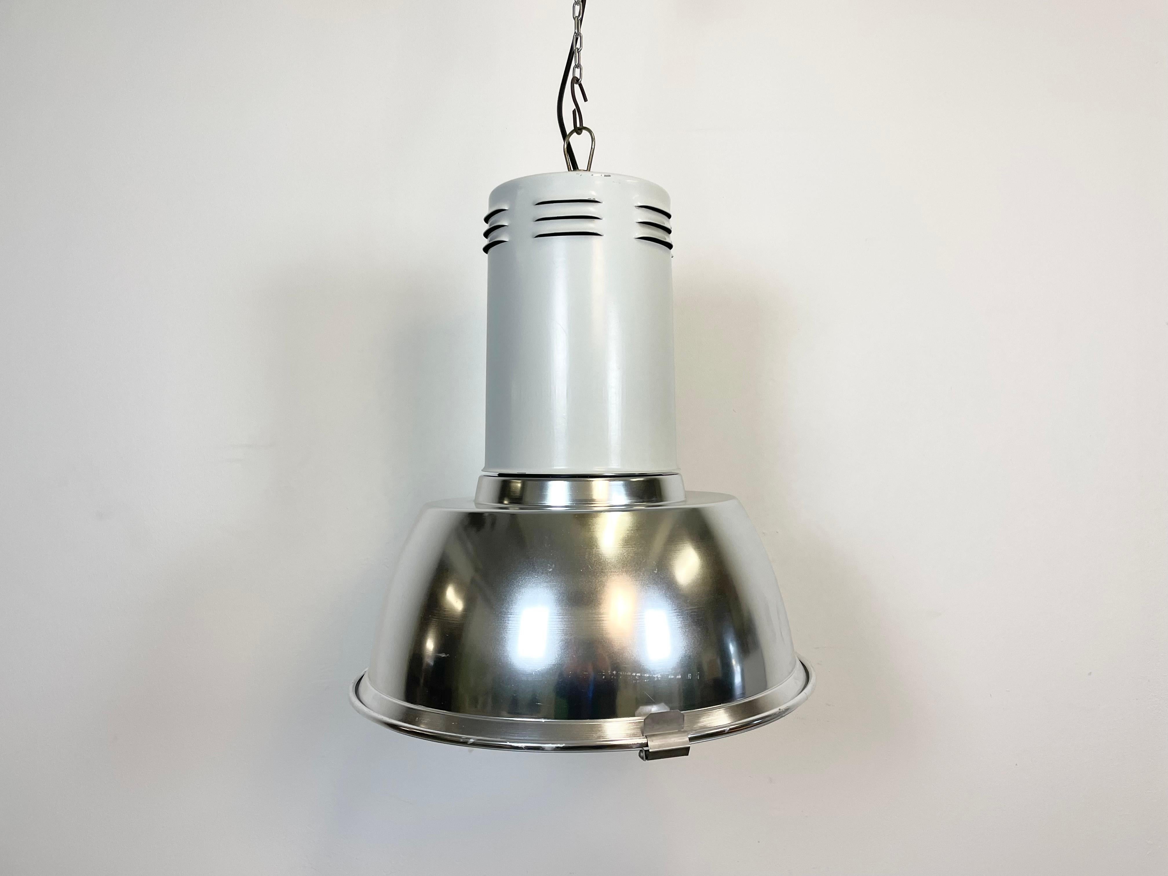 Industrial hall lamp made by Siemens in Germany during the 1980s. It features aluminium shade, iron top and iron grid. The socket requires E 27 light bulb. New wire. The diameter of the shade is 49 cm.The weight of the lamp is 5 kg.