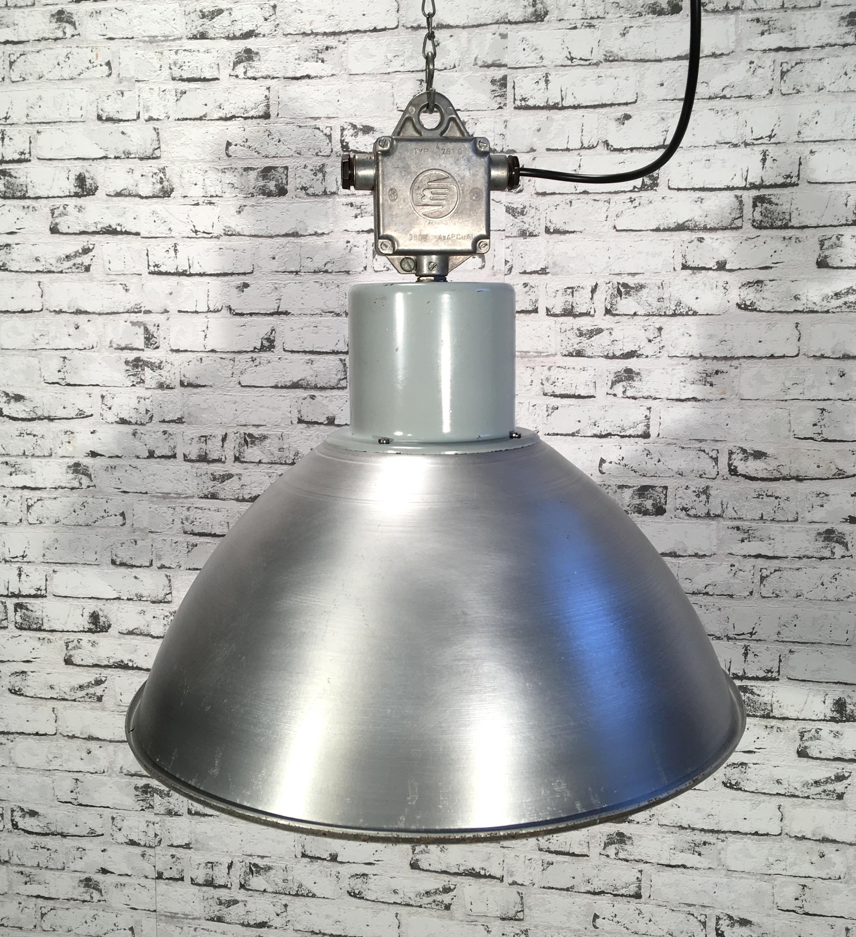 This pendant lamp was originally used in a factory in former Czechoslovakia in the 1960s. The piece is comprised of an aluminum lampshade and a cast aluminum top. The lamp is fully functional and features a new porcelain E27-socket and wire. The