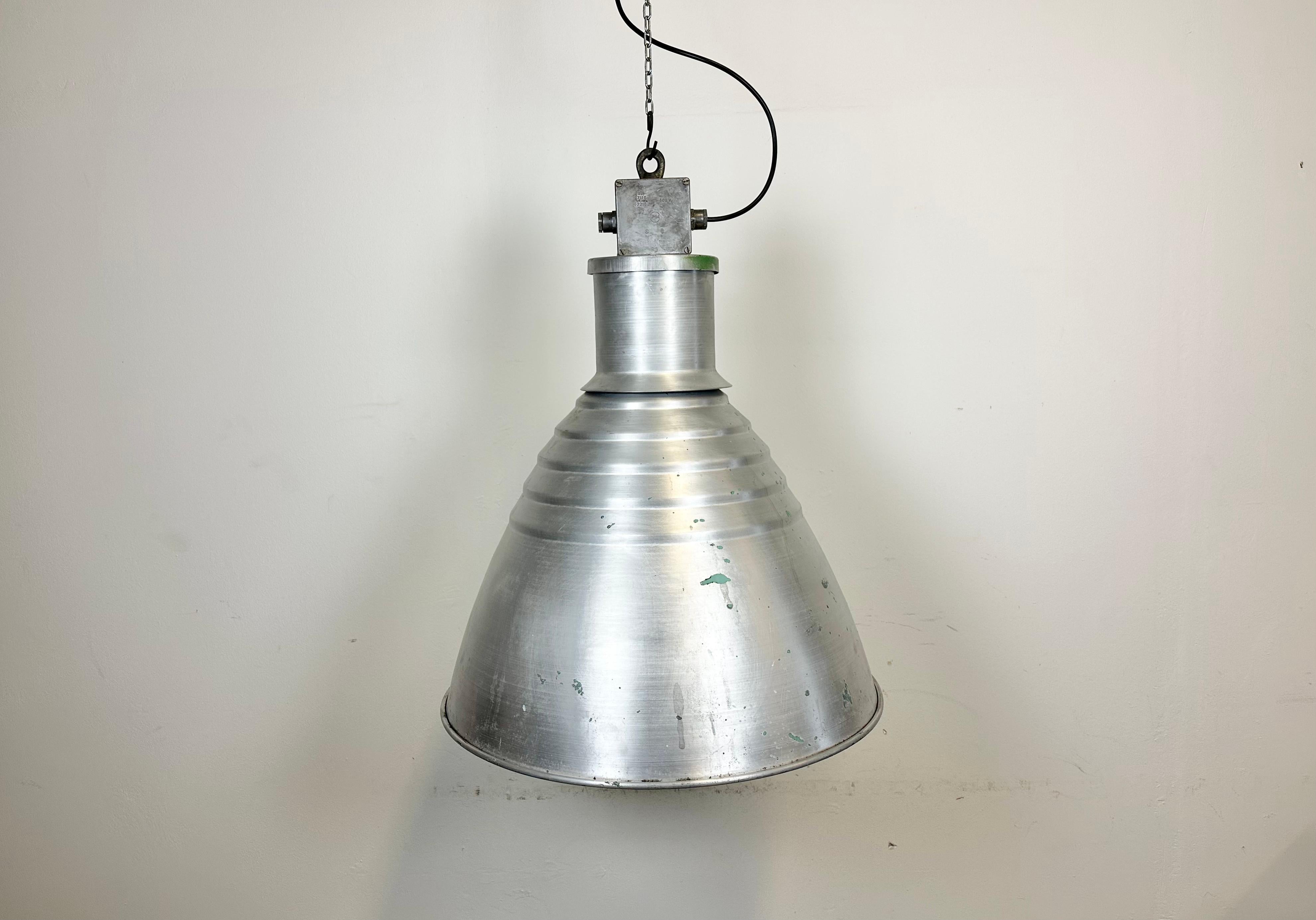 This pendant lamp was made by Elektrosvit and originally used in a factories in former Czechoslovakia in the 1960s. The piece is comprised of an aluminium body and a cast aluminium top box. The lamp is fully functional and features a new porcelain