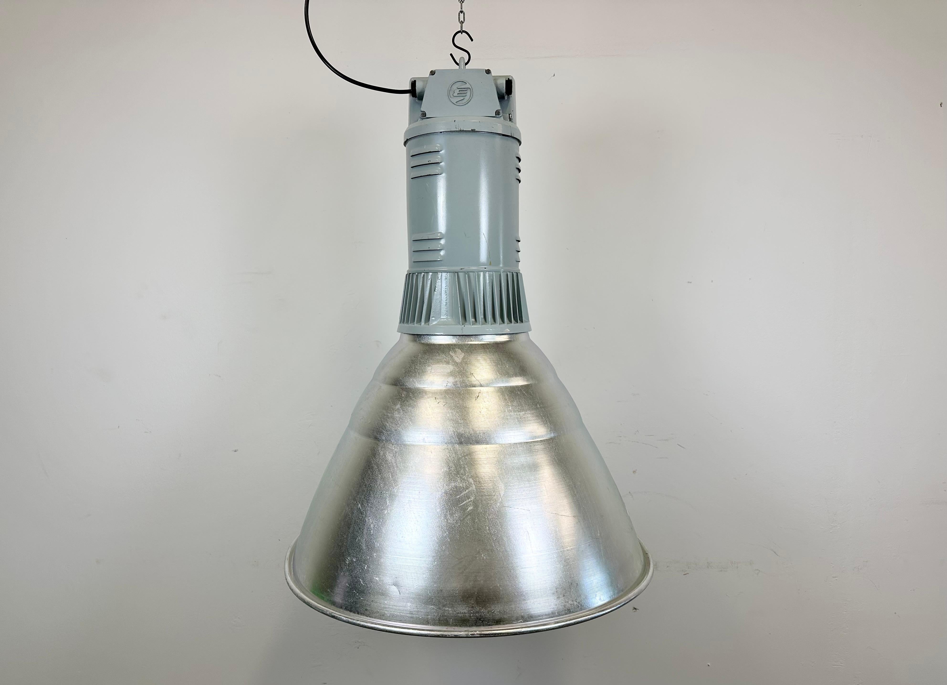 This pendant lamp was made by Elektrosvit and originally used in a factories in former Czechoslovakia in the 1960s. The piece is comprised of an aluminium body and a cast aluminium top. The lamp is fully functional and features a new porcelain E27/