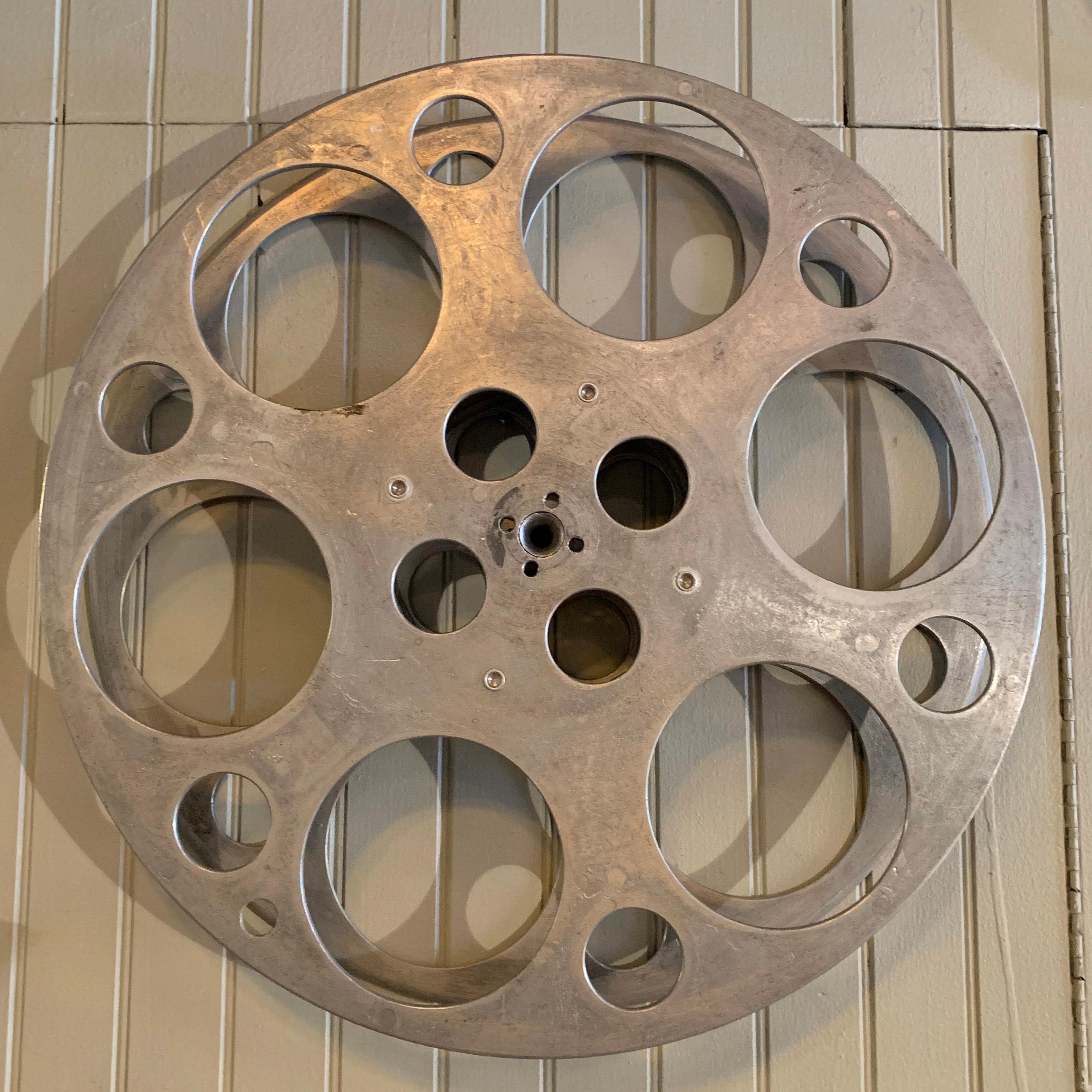 Large, industrial, midcentury, film reel is a great accent piece or wall hanging.
