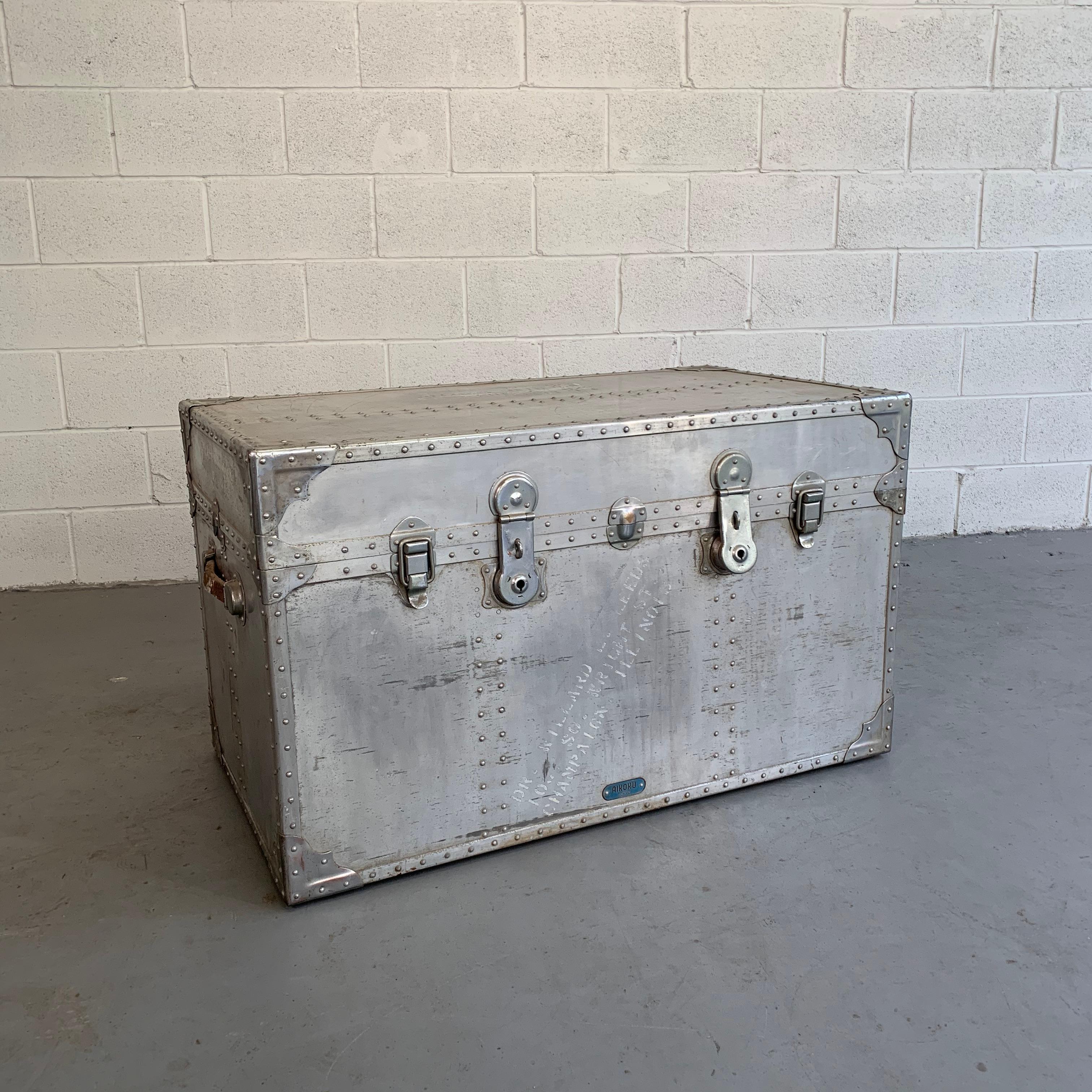 Oversized, industrial, aluminum, military trunk features riveted edges, leather handles and original cargo stamps with its original green painted interior. Other aluminum trunks are available.