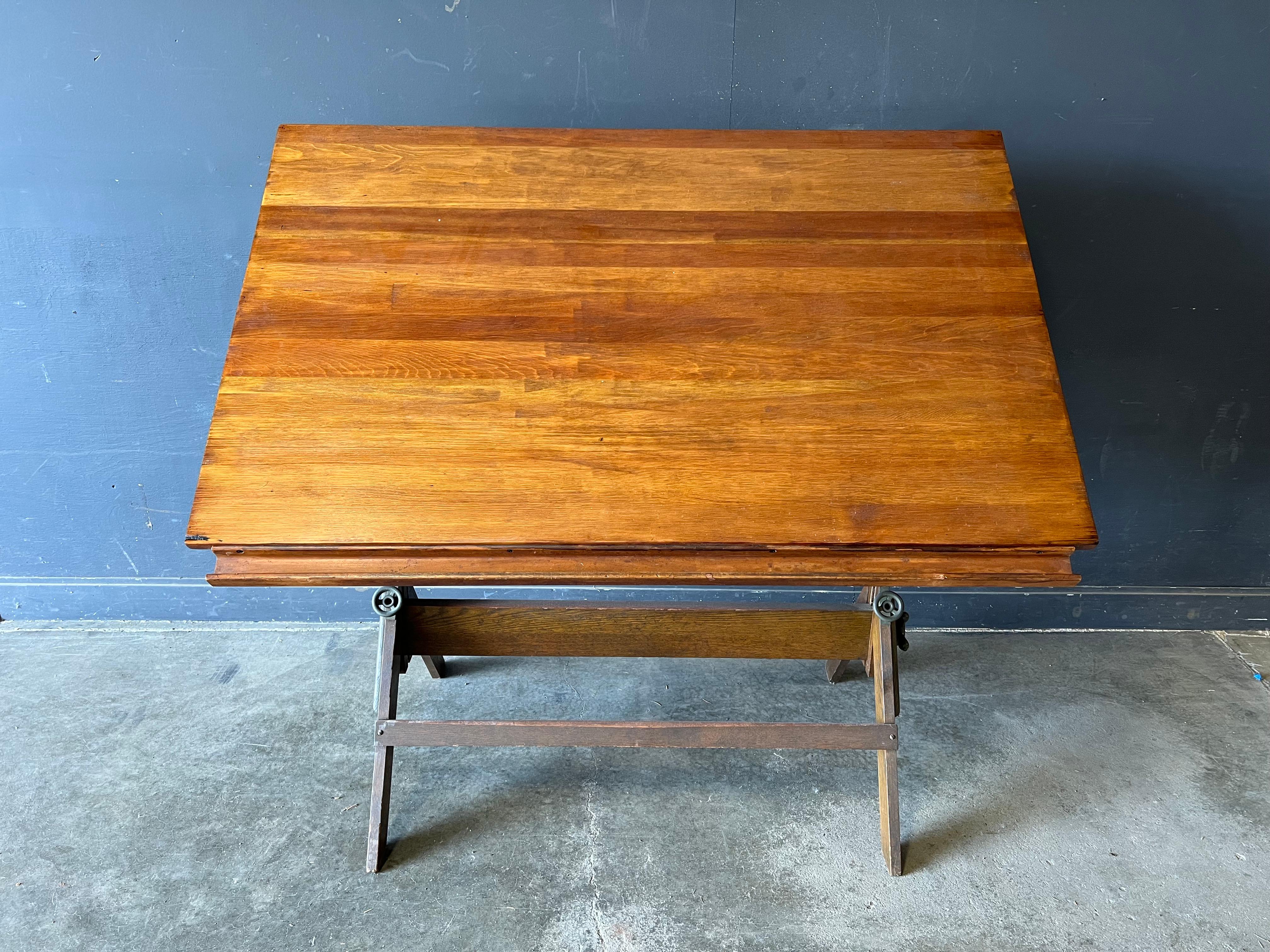 Large Industrial Antique Drafting Table by Dietzgen. A large model with wonderful patina on top. Cast iron handles for adjusting height. Table can be horizontal flat for working desk, or almost vertical and any angle. This is a great example of the