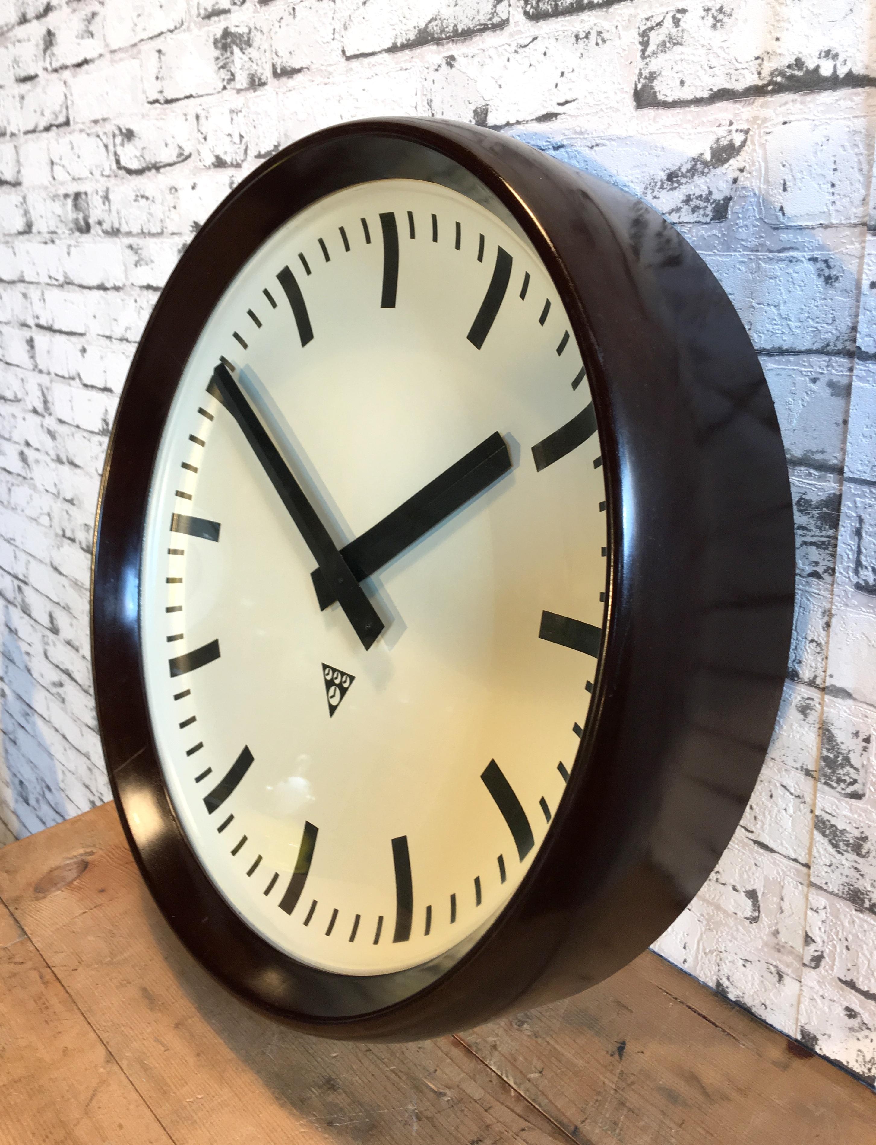 This large wall clock was produced by Pragotron in former Czechoslovakia during the 1960s.It features a brown bakelite frame and clear glass cover.The piece has been converted into a battery-powered clockwork and requires only one AA-battery.