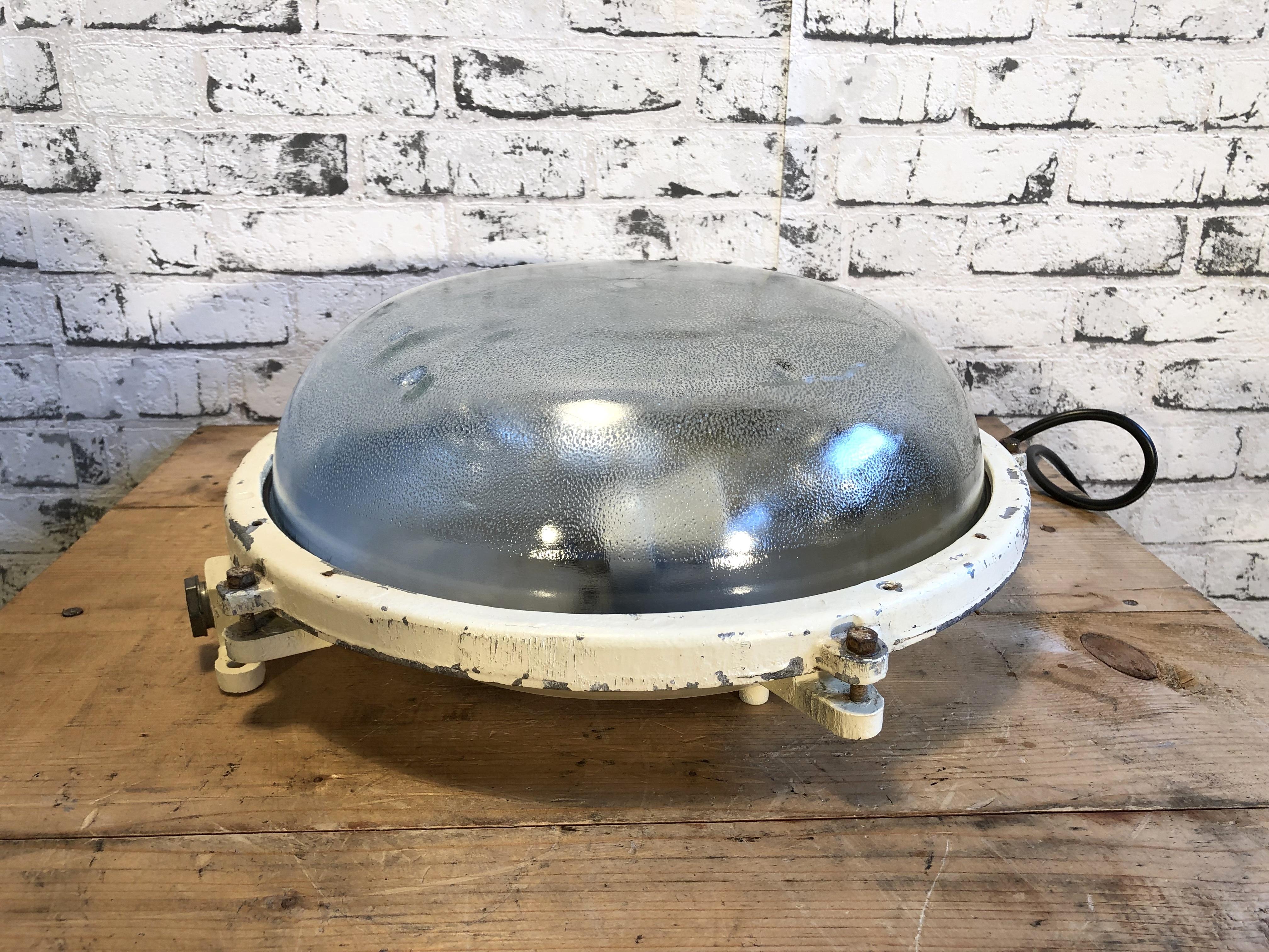 This cast aluminium wall lamp was made by Elektrosvit in former Czechoslovakia during the 1970s. It features cast aluminium body and a frosted curved glass. It can also be used as a ceiling lamp. The lamp has two porcelain sockets for E 27