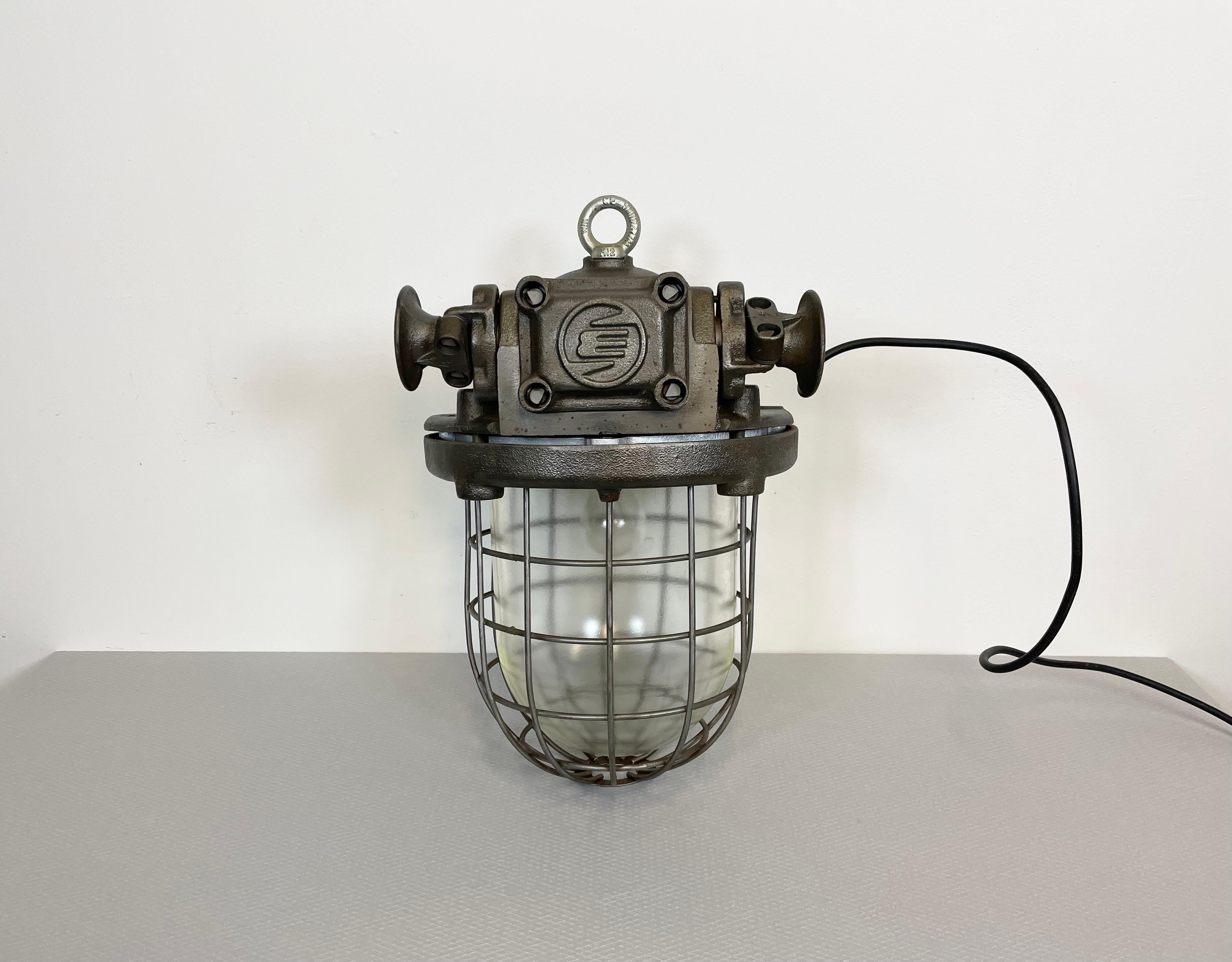 Large heavy industrial hanging lamp made by Elektrosvit in former Czechoslovakia during the 1960s. It features a cast iron body and a clear glass cover. The porcelain socket requires E 27 lightbulbs. New wire. The weight of the lamp is 27 kg !!!!