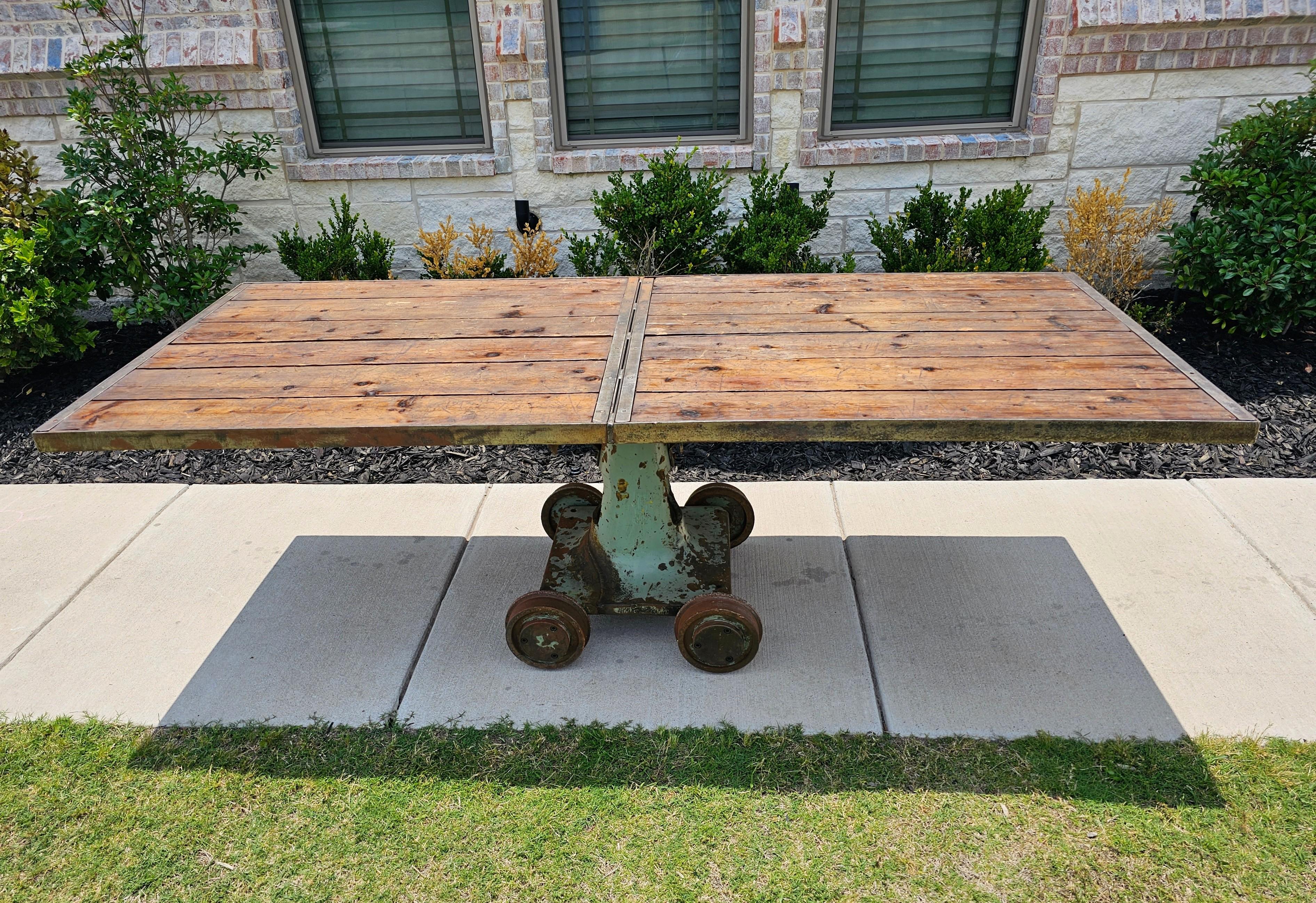 An incredible 20th century rustic industrial style repurposed dining table - kitchen island. 

Crafted from a heavy-duty utilitarian cast iron American factory - warehouse trolley base, circa 1940, with four solid cast iron wheels and cutout