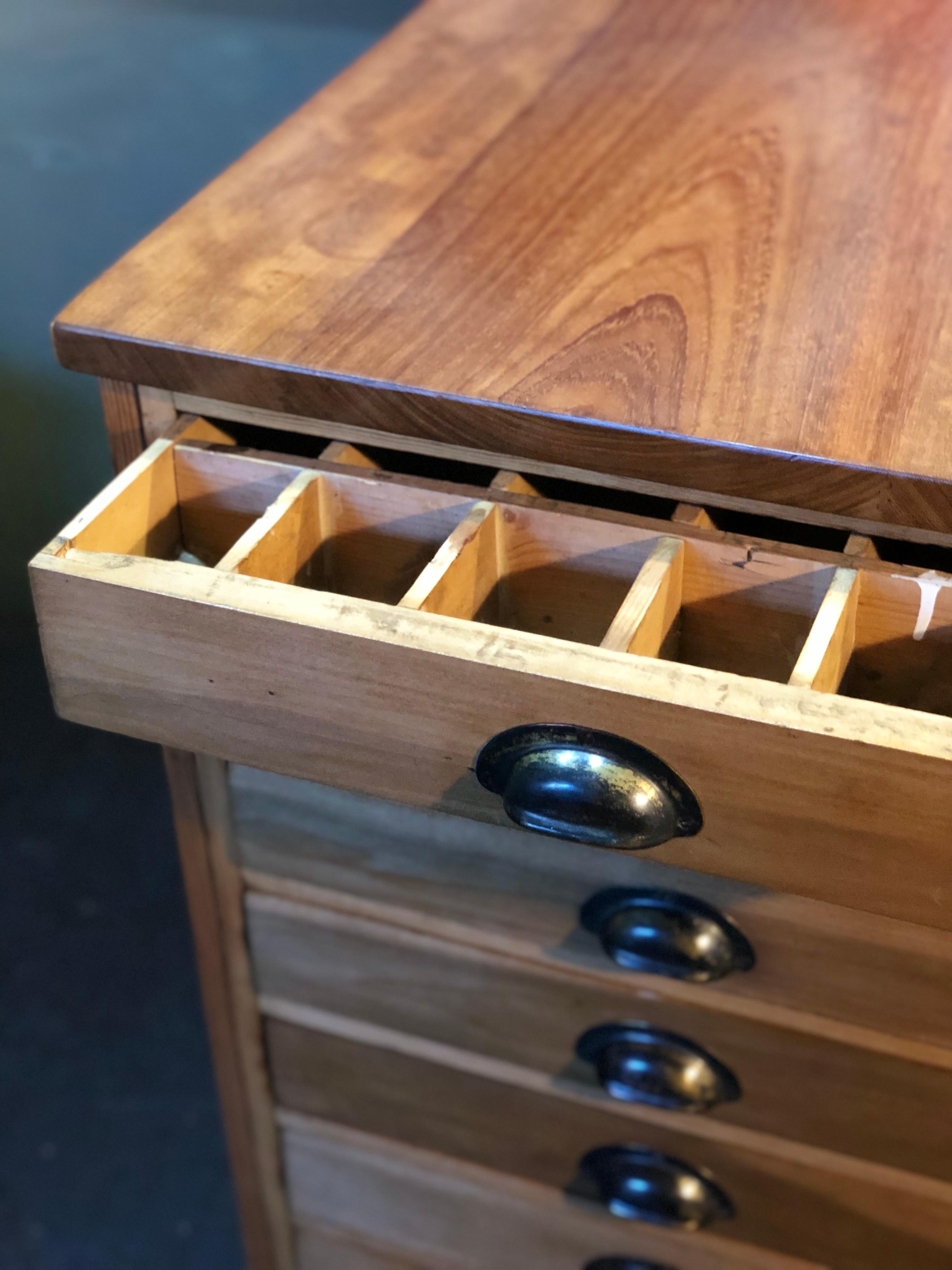 A very large and deep Industrial chest of drawers from the early 20th century. Constructed from pitch pine and mahogany with large original pull handles. These workshop drawers interiors have various compartment configurations.