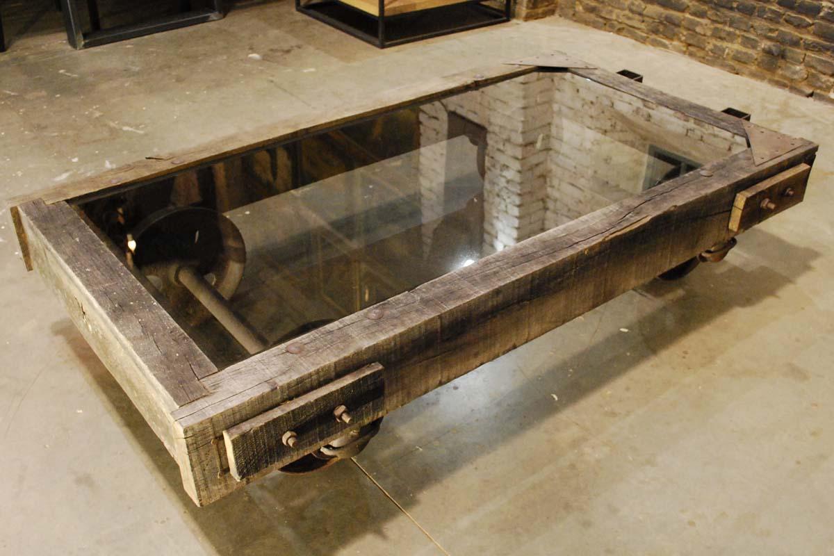 An imposing and rustic large coffee table cart with glass top
The base of the table is made from solid oak beams. The axels, wheels and other hardware is in hand forged steel.
We've inserted a smokey glass hardened top to keep the beautiful steel