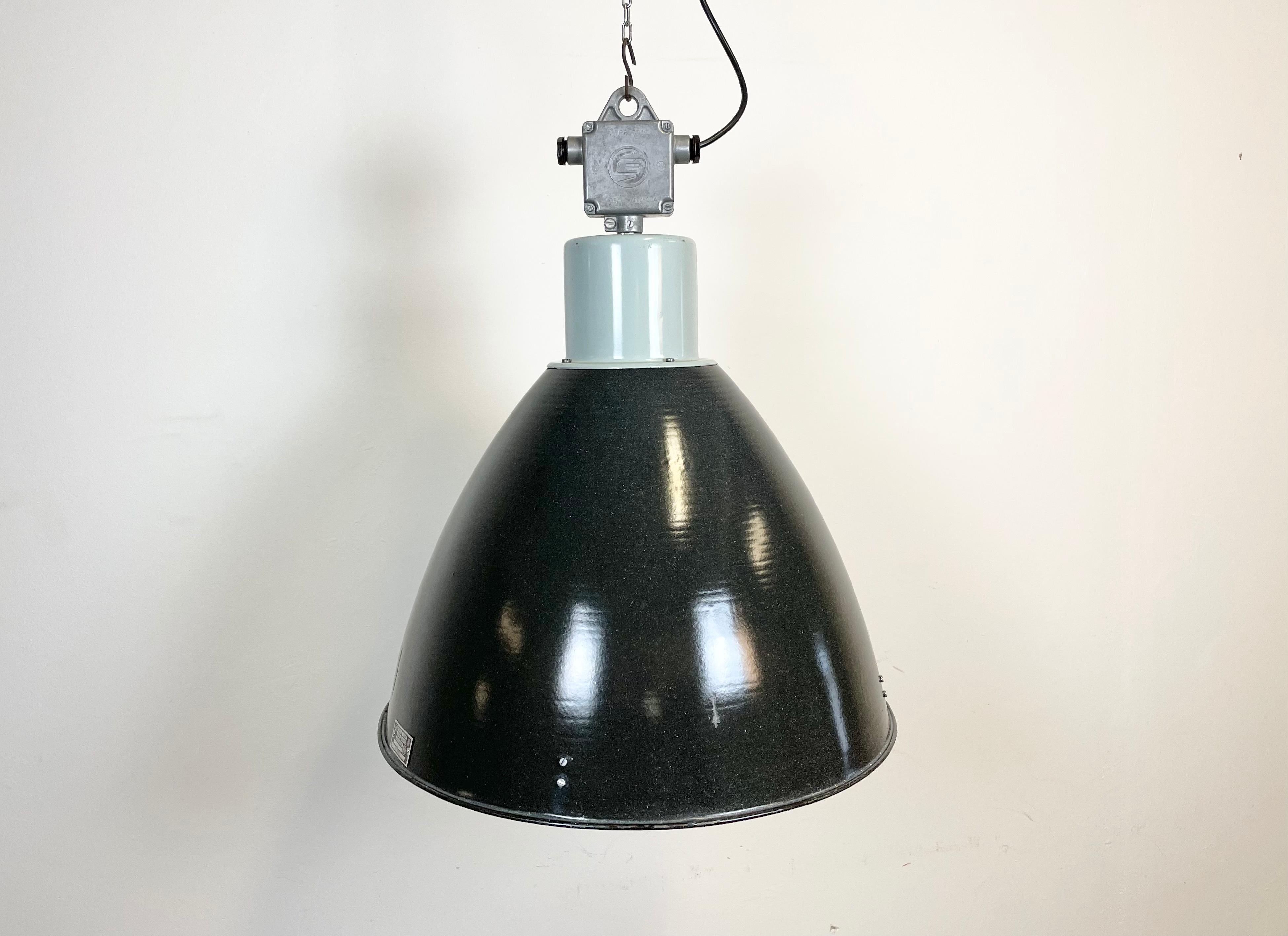 Industrial enamel pendant lamp designed and produced by Elektrosvit in former Czechoslovakia during the 1960s. It features a grey metal top with cast aluminium box and black ( dark grey ) enamel shade with white enamel interior.
New porcelain
