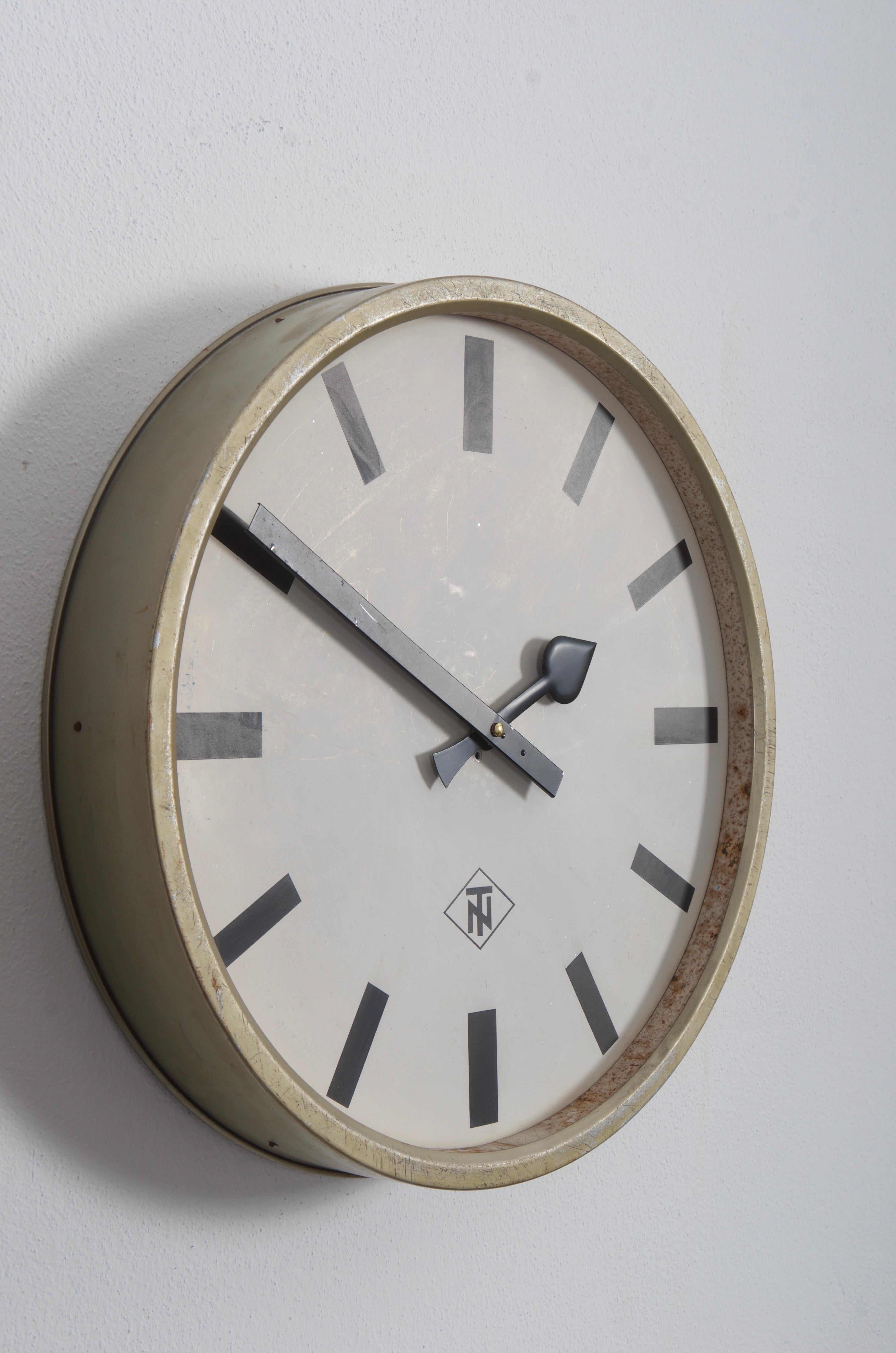 Steel frame painted with an aluminum clock face, clock hand and glass cover. Made in Germany in the late 1960s by TN (Telefonbau und Normalzeit). Formerly a slave clock, it is now fitted with a modern quartz movement with an AA battery. Some use