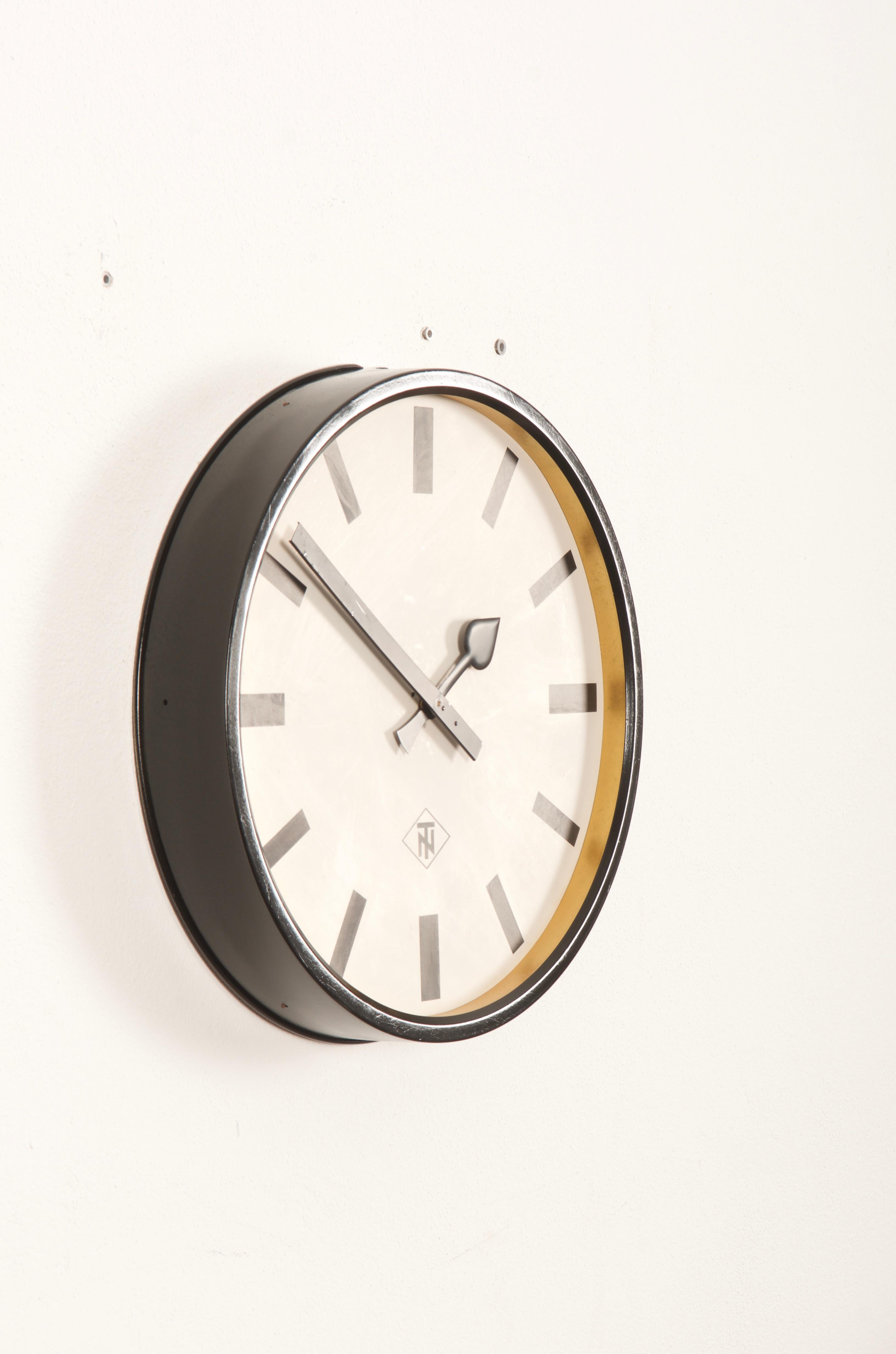 Steel frame painted with an aluminum clock face, clock hand. Made in Germany in the late 1960s by TN (Telefonbau und Normalzeit). Formerly a slave clock, it is now fitted with a modern quartz movement with an AA battery. Some use marks on the clock