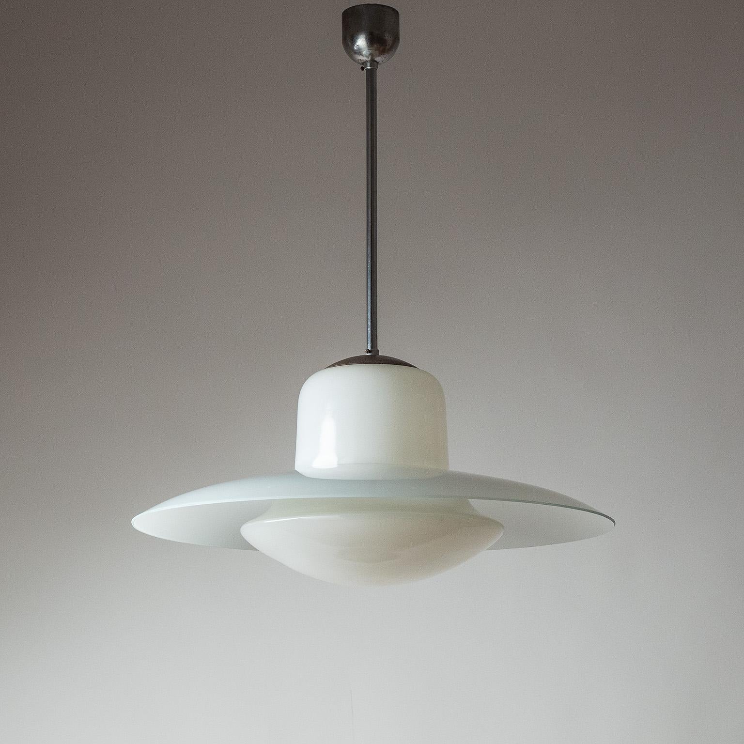 Large industrial dual-glass pendant from the 1940s. Two blown glass elements with partial white enamel hang from minimal chromed hardware. Nice original condition with some patina on the metal parts. One original brass E27 socket with new