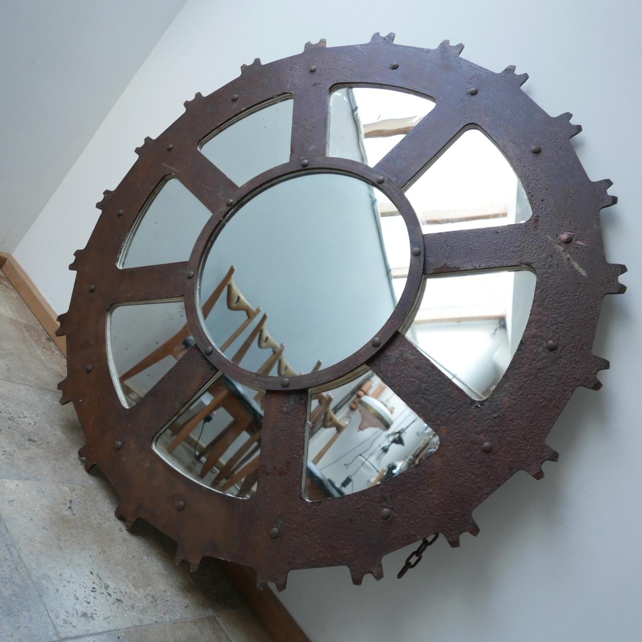 A large industrial mirror of circular form. 

Believed to be an industrial cog or mould with later mirror added. 

Heavy and good quality. 

Hanging chain included and integrated. 

Location: London Gallery. 

Dimensions: 143 diameter x 5
