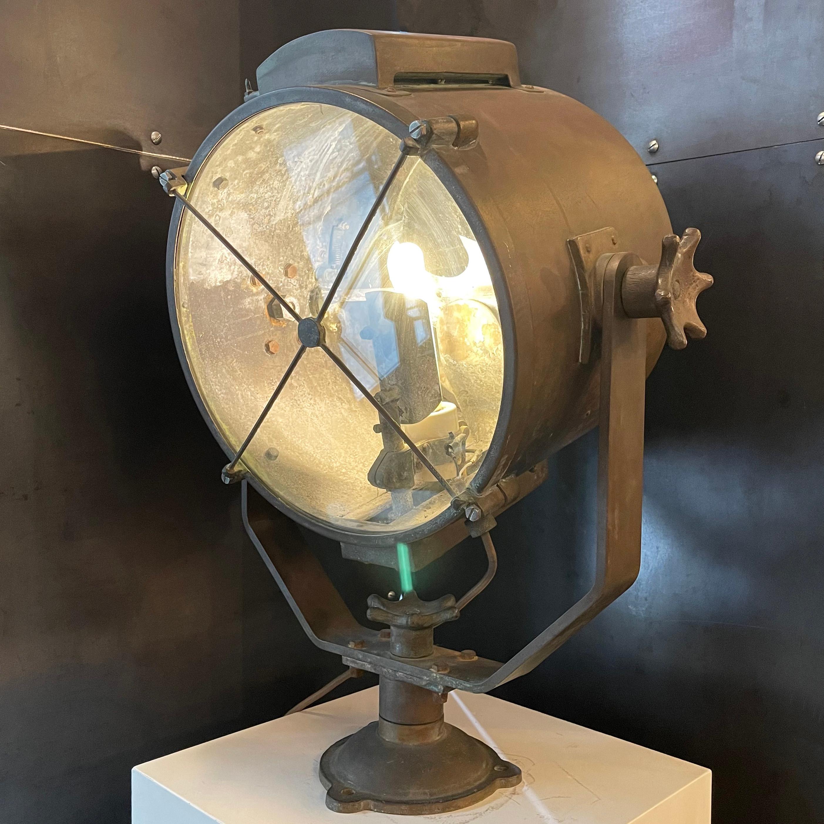 Impressive, antique, industrial, nautical, copper searchlight with glass shade, swivels 360 degrees horizontal and articulates 180 degrees lateral. The interior features a concave mirrored reflector and functioning signal diffuser. The copper