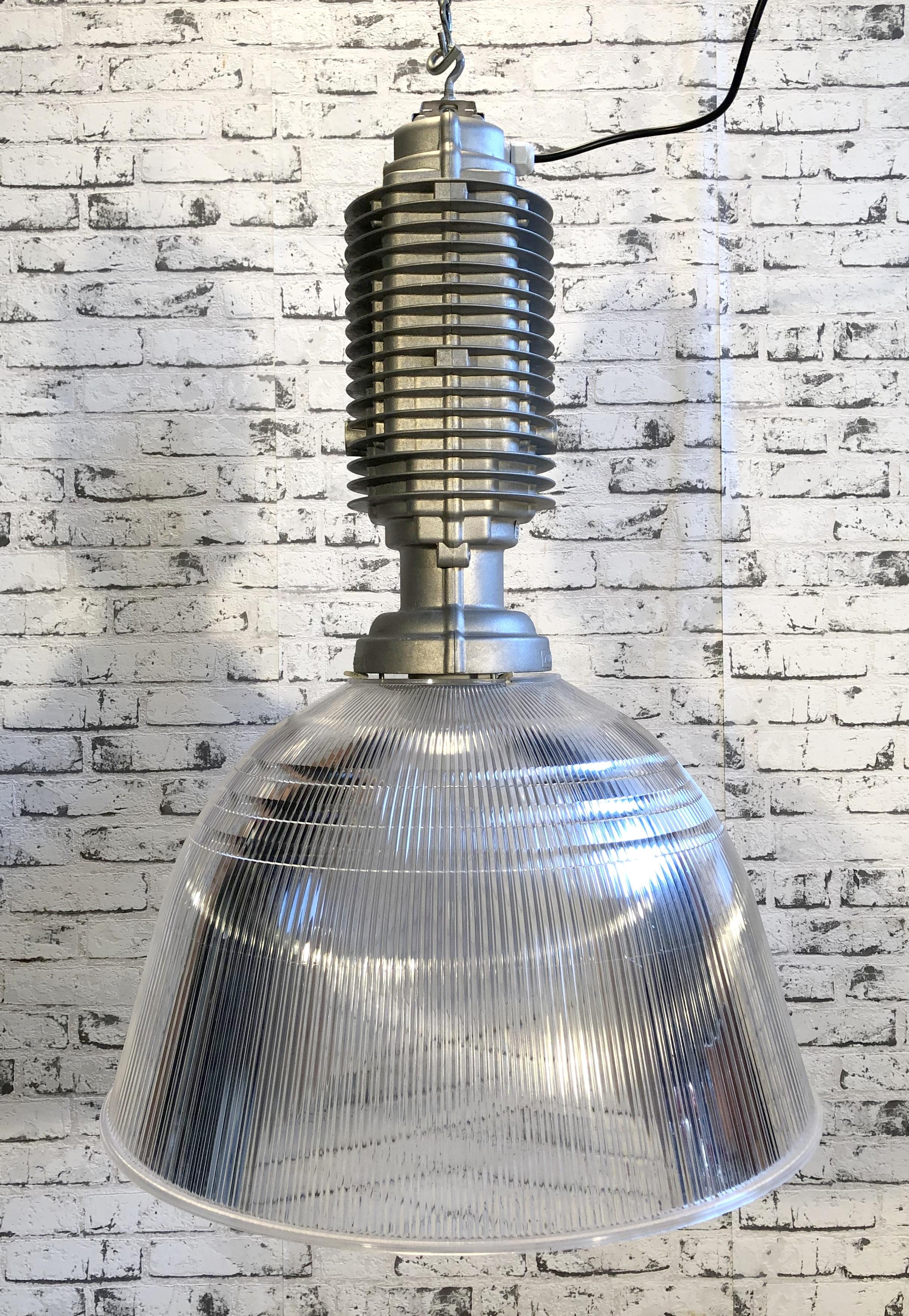 This industrial pendant was designed by Charles Keller for Zumtobel and was used in factories. It features cast aluminum top, transparent plastic shade, new porcelain socket for E27 bulbs and new wire. It weighs 7 kg. Diameter 55 cm.