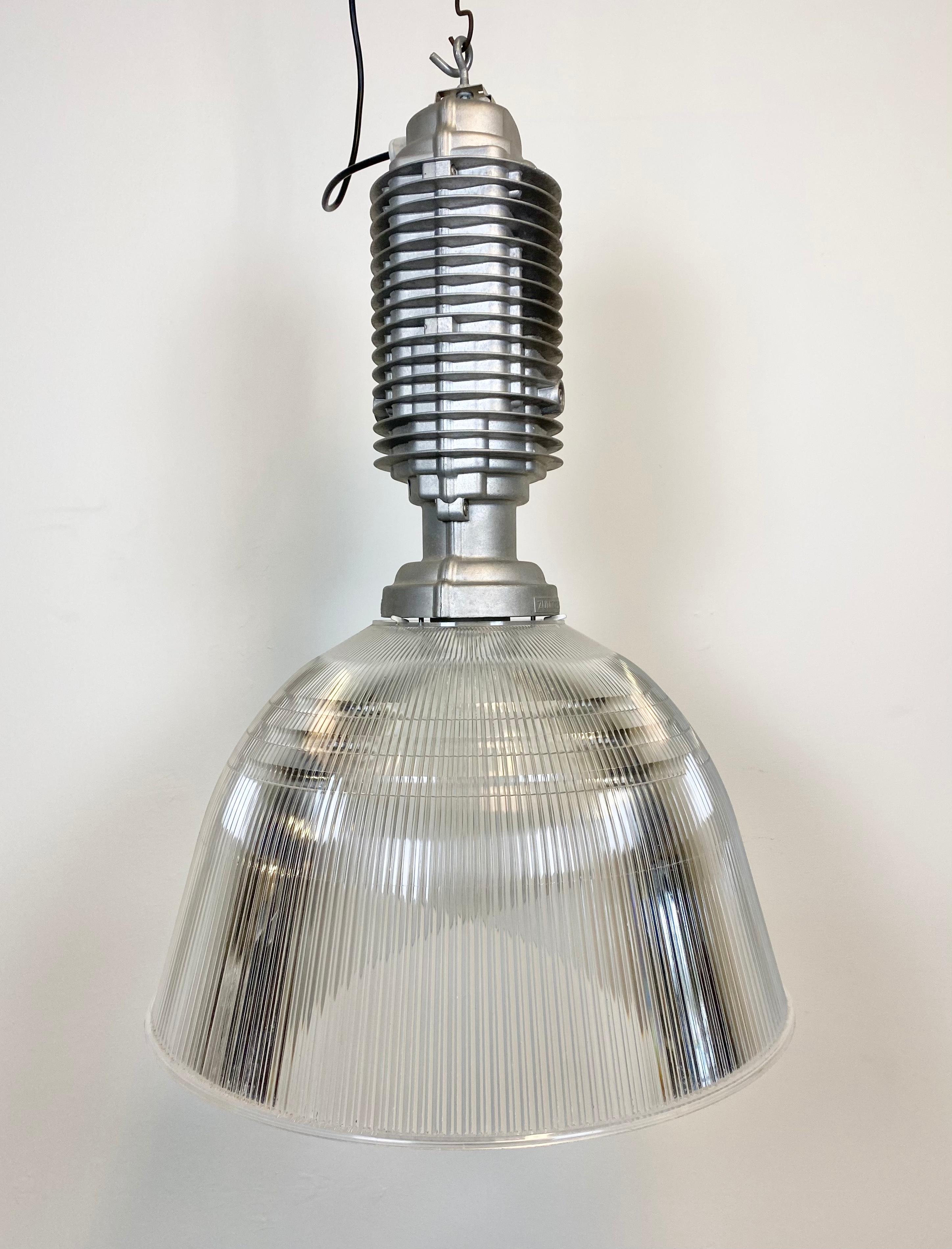 This Industrial pendant lamp was designed by Charles Keller for Zumtobel Staff during the 1990s. It features a cast aluminum top and a transparent plastic shade. New porcelain socket for E27 lightbulbs and new wire. The diameter of the shade is 55