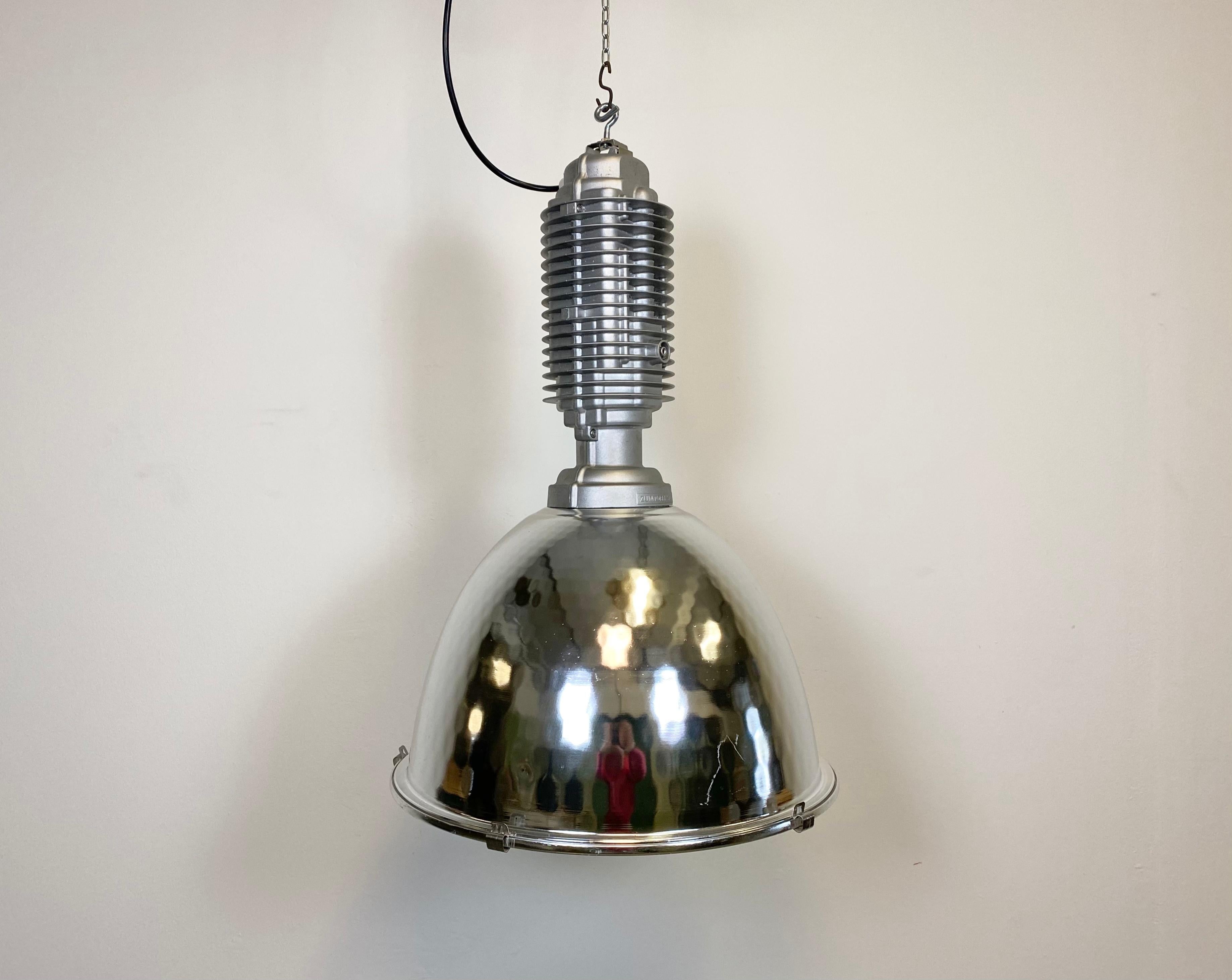 This industrial pendant light was designed by Charles Keller for Zumtobel Staff and was used in factories. It features a cast aluminum top,an aluminium shade with clear glass cover, a socket for E27 light bulbs and new wire. It weights 7,5 kg. The