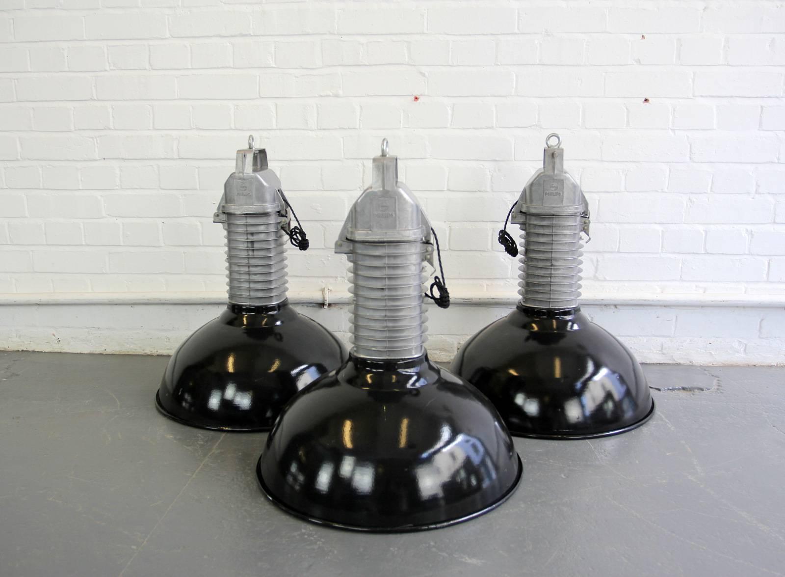 Large industrial pendant lights by Phillips, circa 1950s.

Product code #OA527

- Price is per light (3 available)
- Vitreous black enamel shade
- White enamel inner reflector
- Cast aluminium finned tops
- Comes with 100cm of black braided