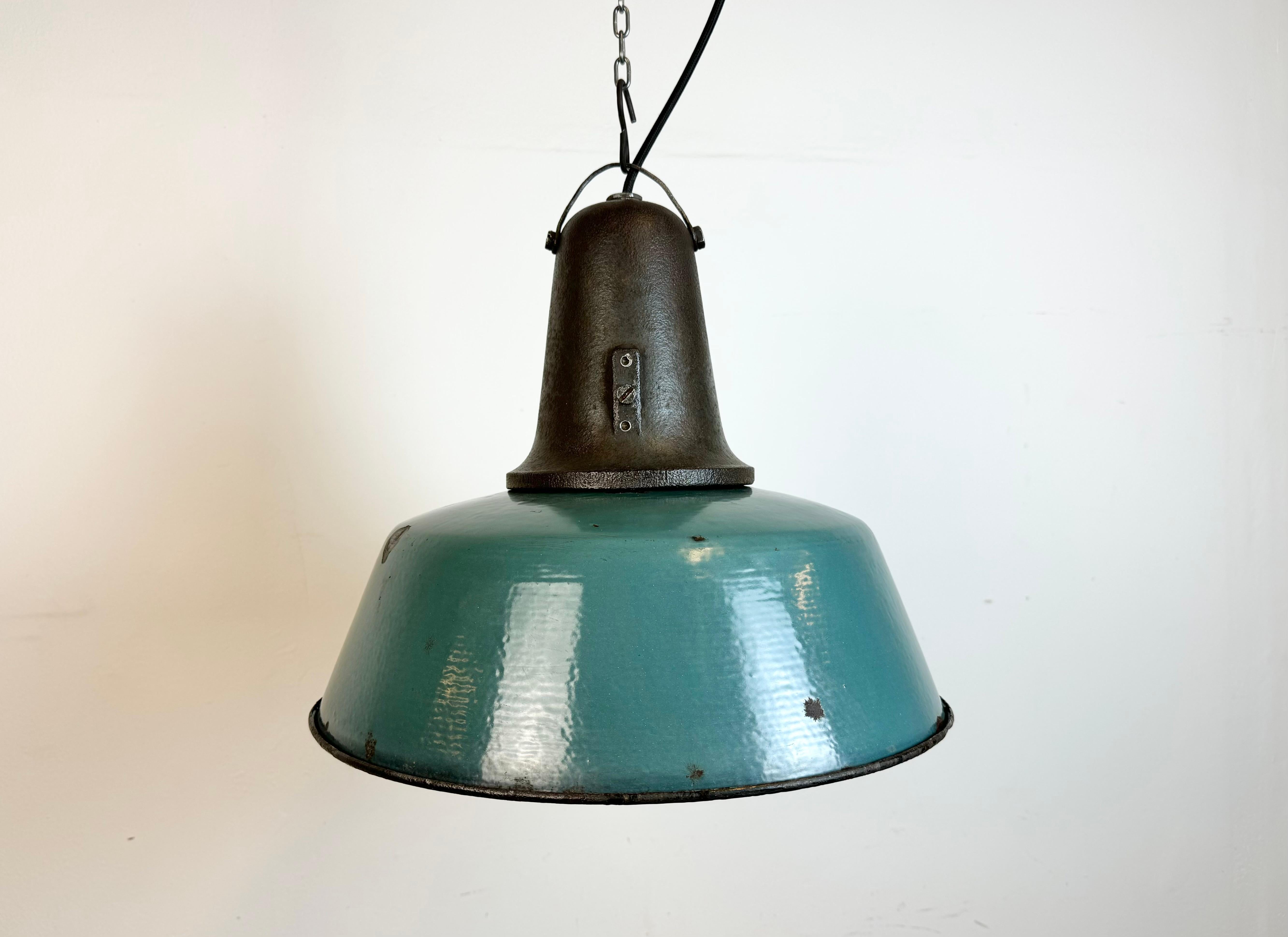 Industrial petrol enamel pendant light made in Poland during the 1960s. White enamel inside the shade. Cast iron top. The porcelain socket requires standard E 27/ E26 light bulbs. New wire. Fully functional. The weight of the lamp is 4,5 kg.