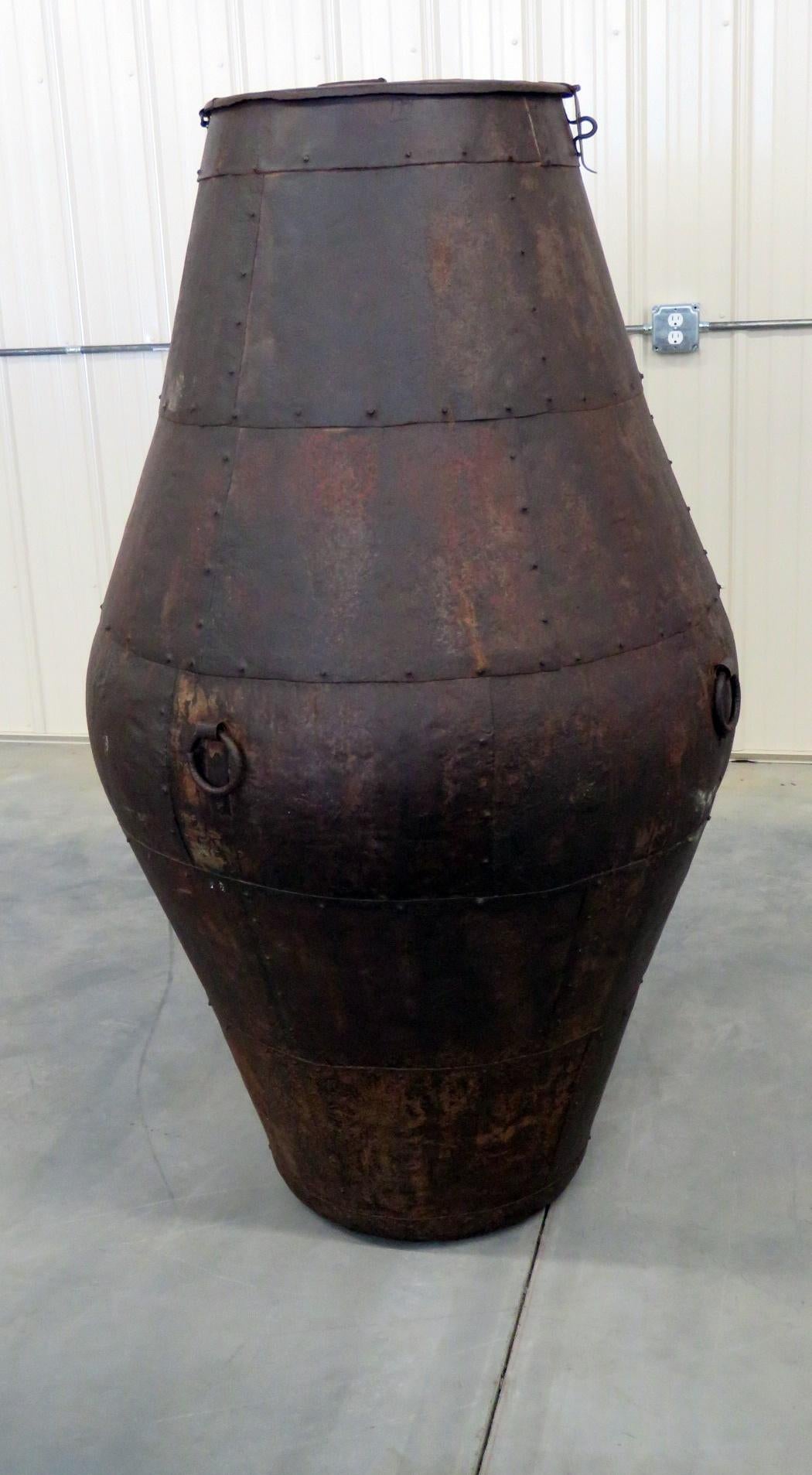 Large industrial style metal urn with 4 handles.