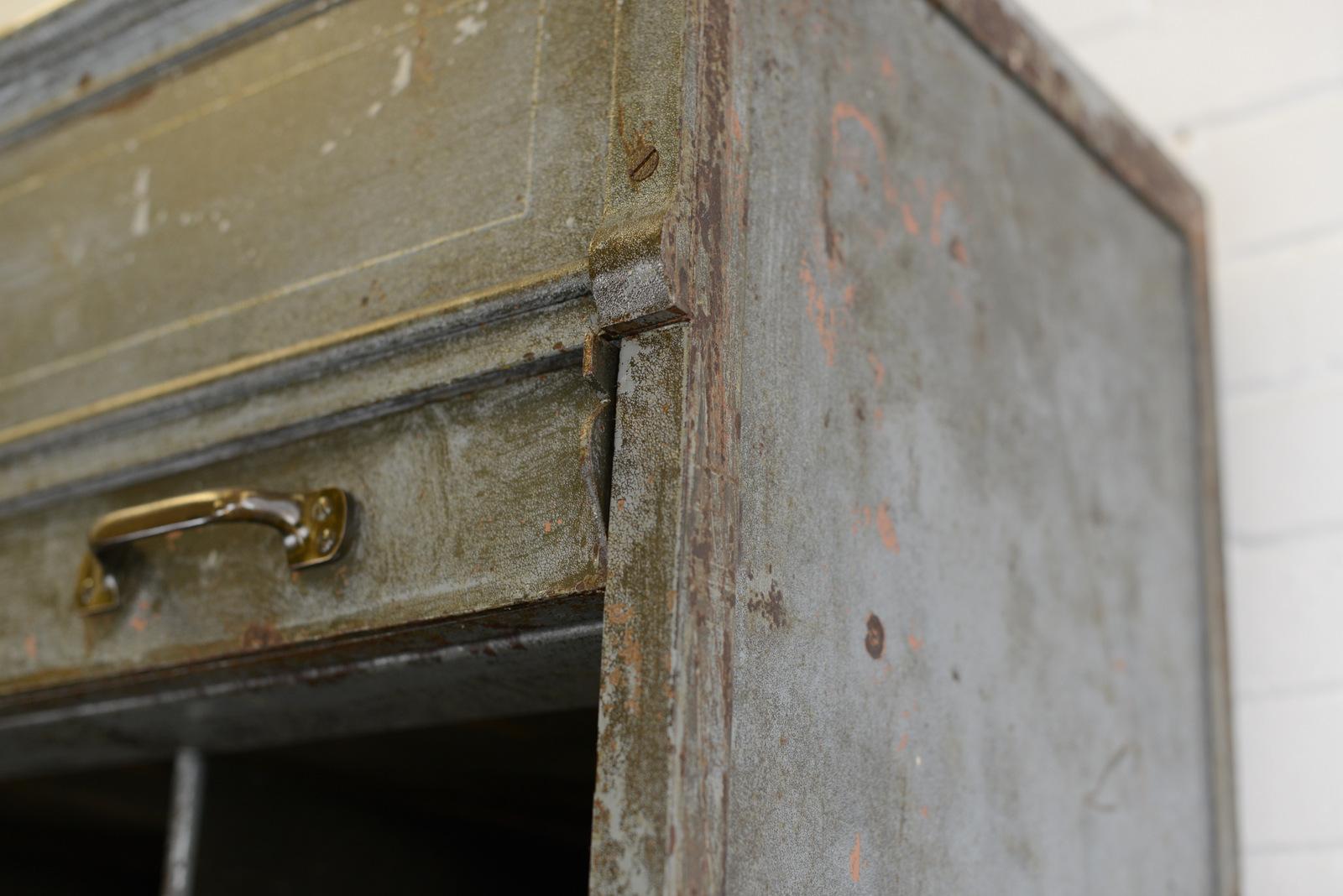 Large industrial tambour fronted cabinet by Strafor, circa 1920s

- Steel frame and tambour
- Solid brass handles
- Brass makers badge
- 30 pigeon holes
- Beautifully crackled and worn grey paint 
- French, 1920s
- Measures: 100 cm wide x 47