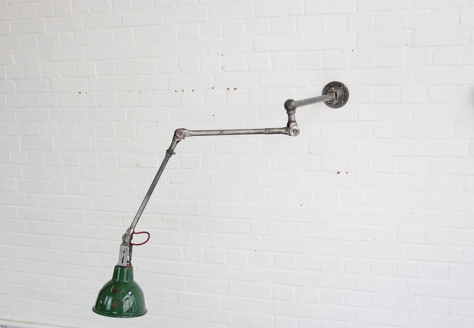 Large industrial task lamp by Dugdills, circa 1930s

- Vitreous green enamel shade
- Tubular steel articulated arms
- Wires directly into a wall or ceiling feed
- Debossed branding on the base
- Takes B22 fitting bulbs
- Inline switch on the