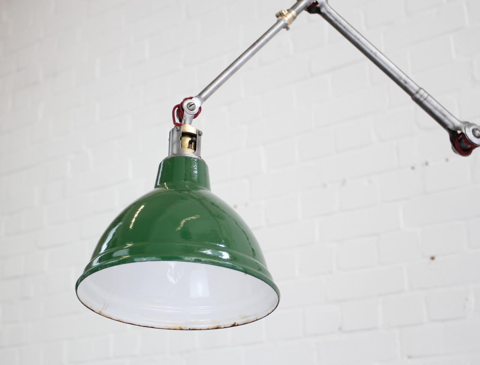 Large industrial task lamp by Dugdills, circa 1930s.

- Vitreous green enamel shade
- Tubular steel articulated arms
- Wires directly into a wall or ceiling feed
- Debossed branding on the base
- Takes B22 fitting bulbs
- Inline switch on the