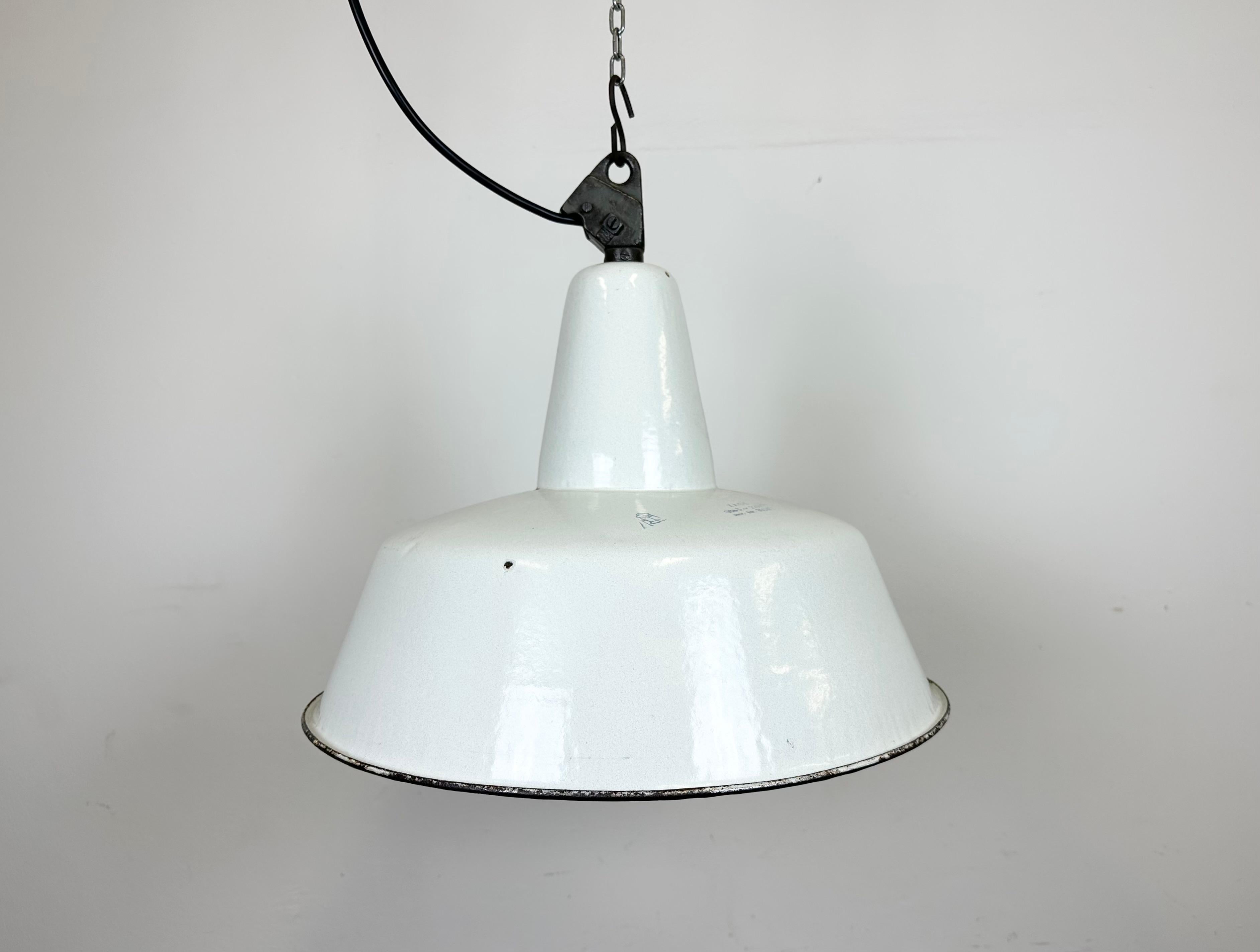 Industrial white enamel pendant light made by Zaos in Poland during the 1960s. White enamel inside the shade. Cast iron top. The socket requires E 27/ E 26 light bulbs. New wire. The weight of the lamp is 2.3 kg.The diameter of the lamp is 42 cm.