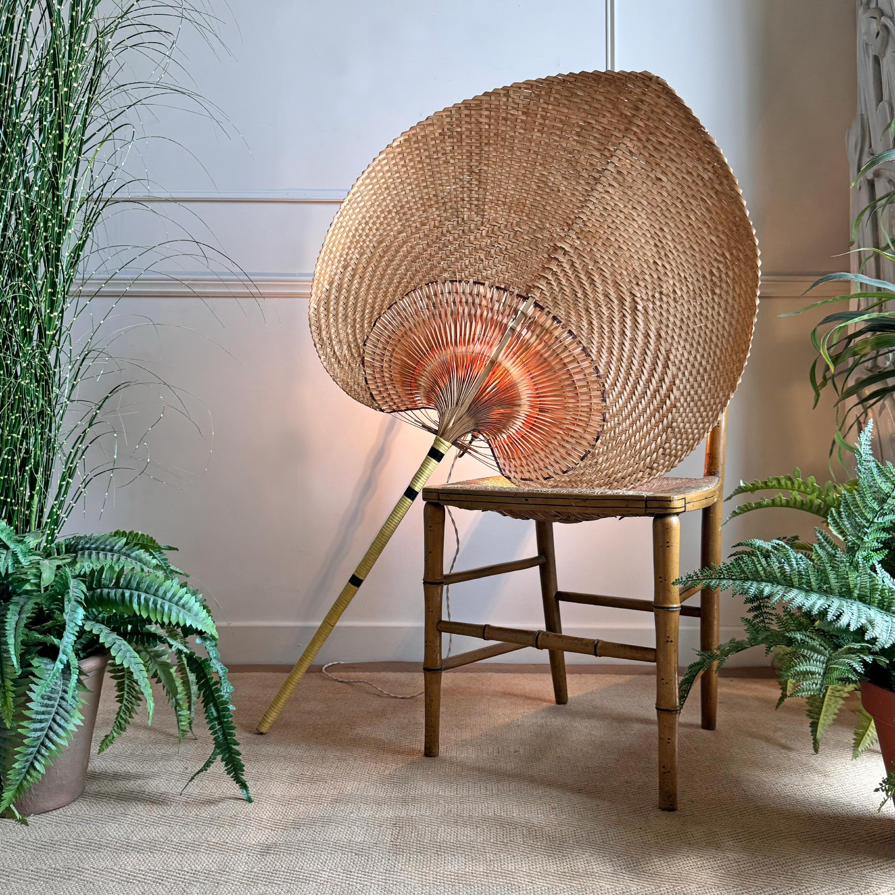 An impressive and very large scale Uchiwa (fan) wall light, very much in the manner of Ingo Maurer (this is not an Ingo Maurer Uchiwa), the huge fan constructed of split bamboo and woven grass, with a single e14 (small screw in) gold edison lamp