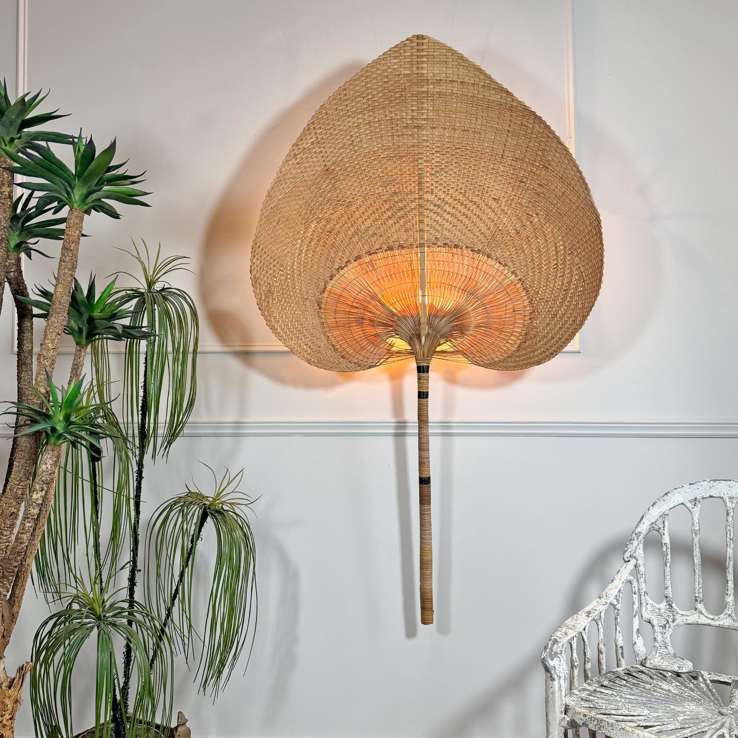 Un'impressionante lampada da parete Uchiwa (ventaglio) di grandi dimensioni, molto simile a Ingo Maurer (questo non è un Ingo Maurer Uchiwa), con un enorme ventaglio costruito in bambù spaccato ed erba intrecciata, con un singolo portalampada e14