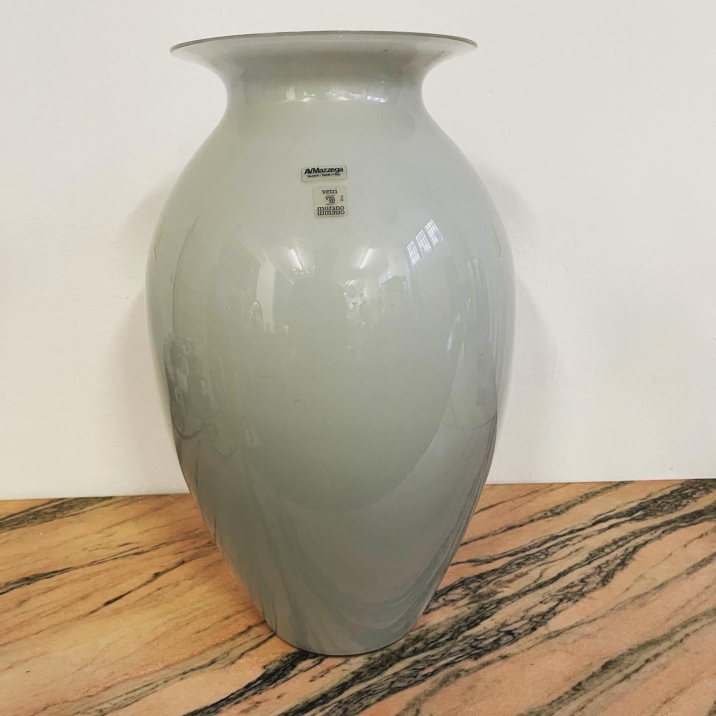 L'élégant vase en verre opalin gris de la verrerie de Murano AVMazzega est une splendide œuvre d'art en verre, réalisée en verre opalin de haute qualité. Le vase est de grande taille, ce qui lui confère une présence imposante dans n'importe quelle