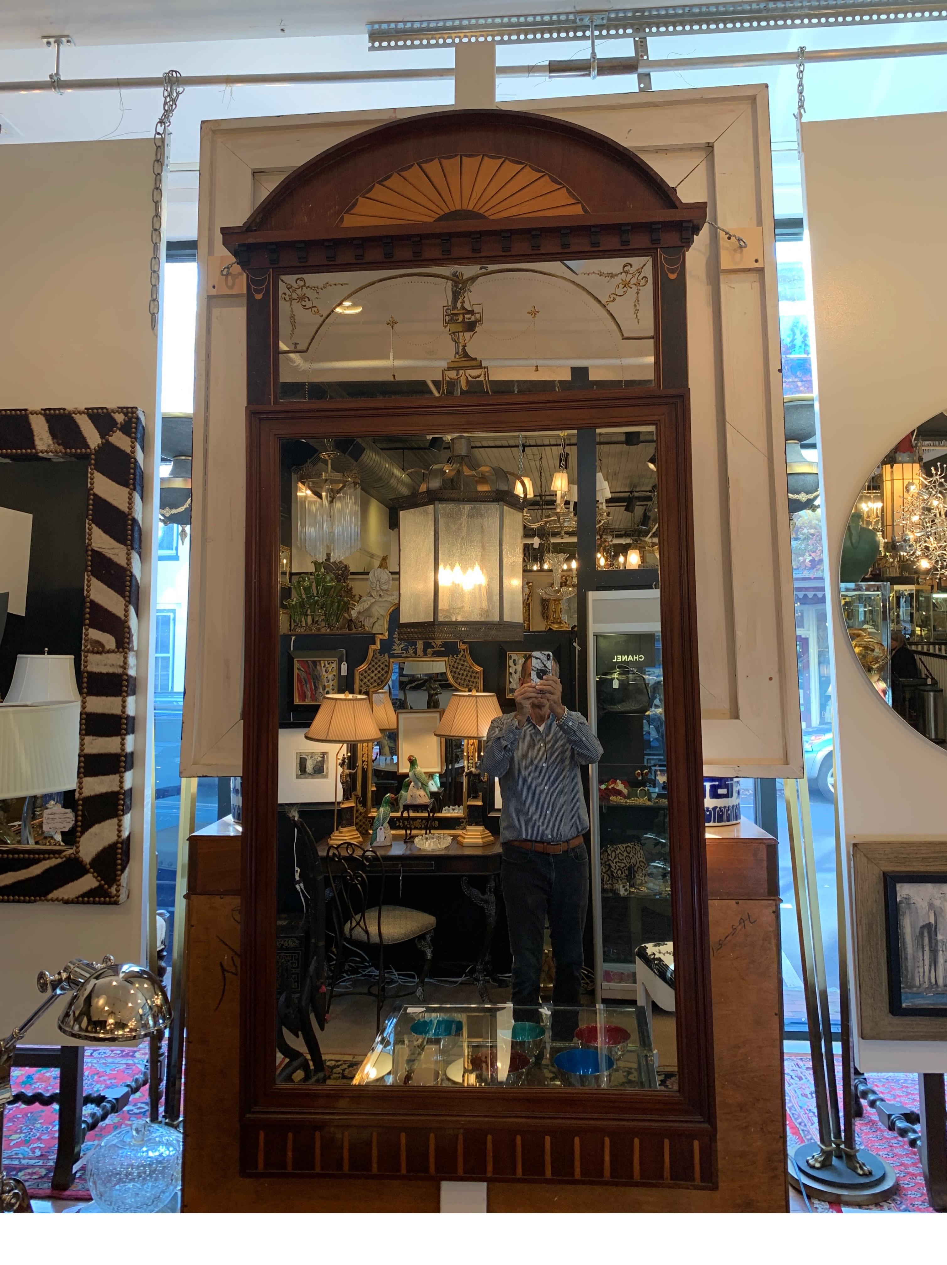 Elegant mahogany and satinwood inlaid framed mirror. Large size with a fan inlay top with gilt decorated upper mirror and generous lower mirror surrounded by inlaid detailed frame. Total height is 82 inches. I 